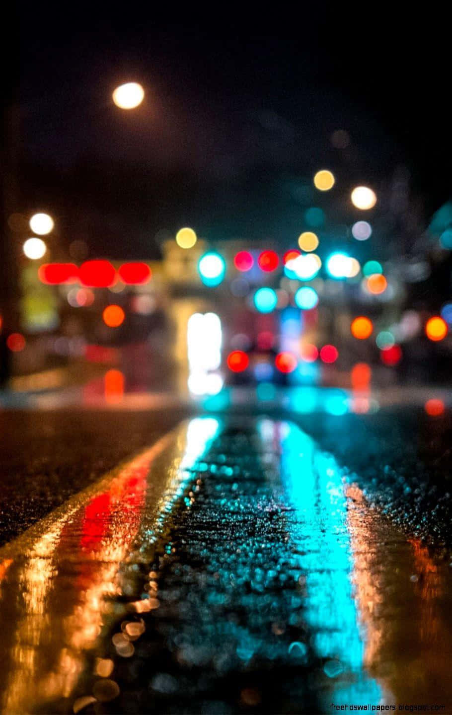 En gade med lys og regn på den. Wallpaper