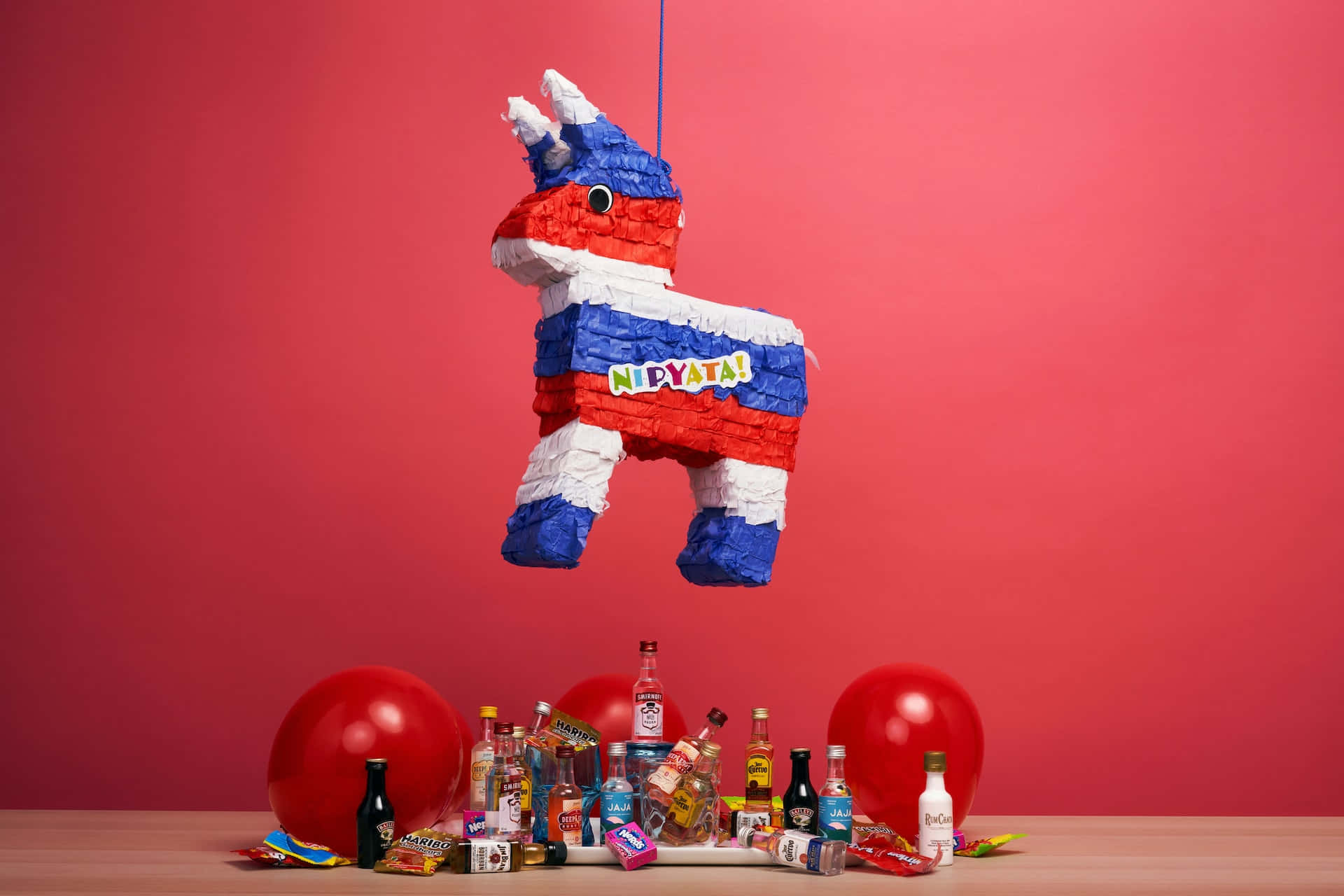 A Pinata Hanging From A Red Table With Balloons And Drinks Wallpaper