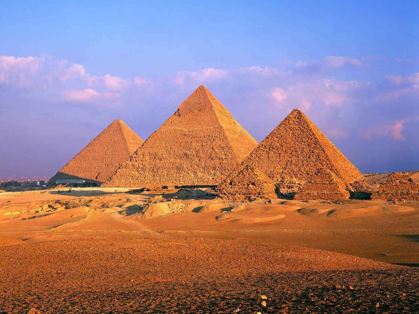 Majestic Giza Pyramids Bathed in Golden Sunset Glow Wallpaper