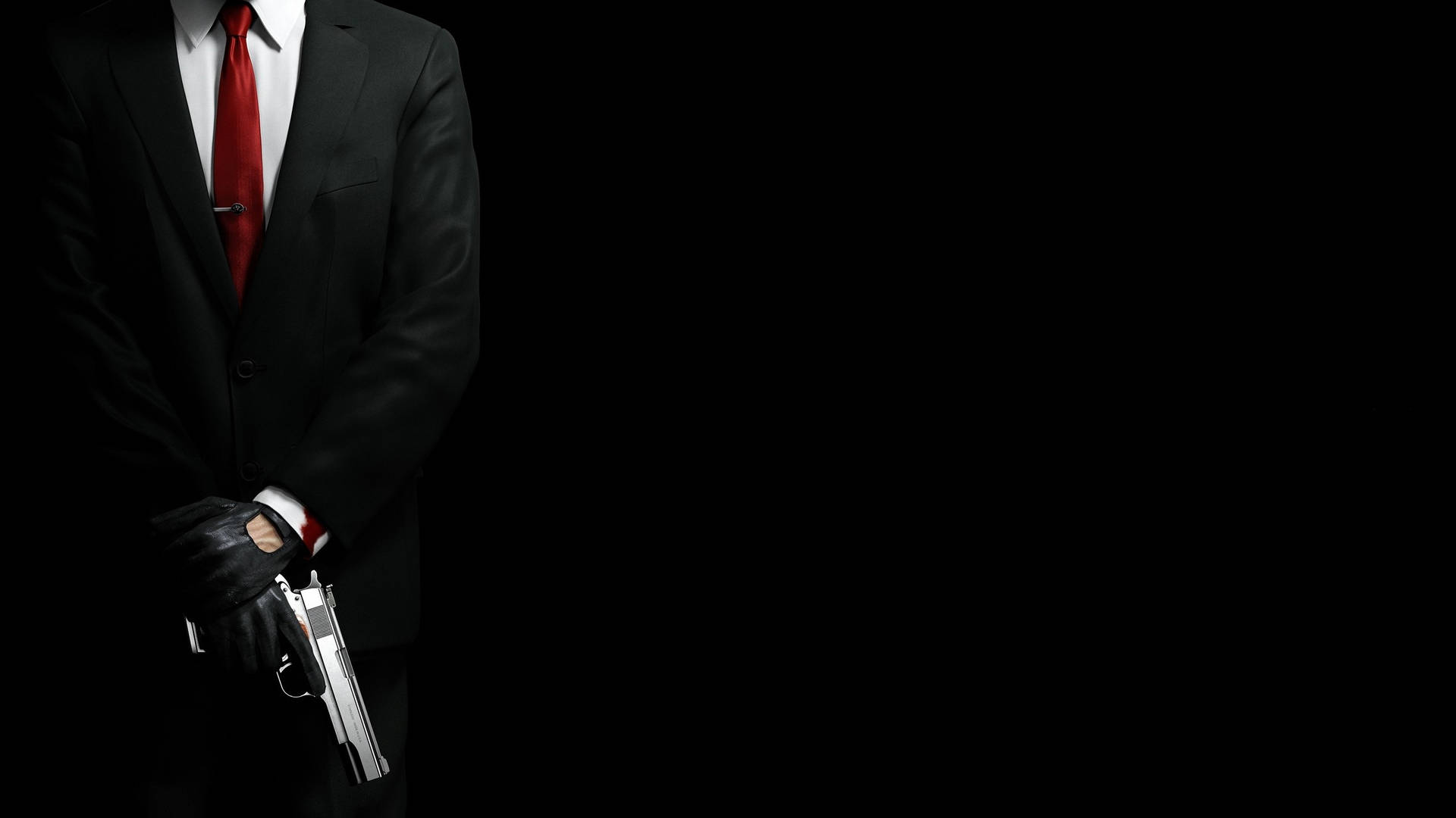 En mand i jakkesæt og slips, der holder et gevær Wallpaper