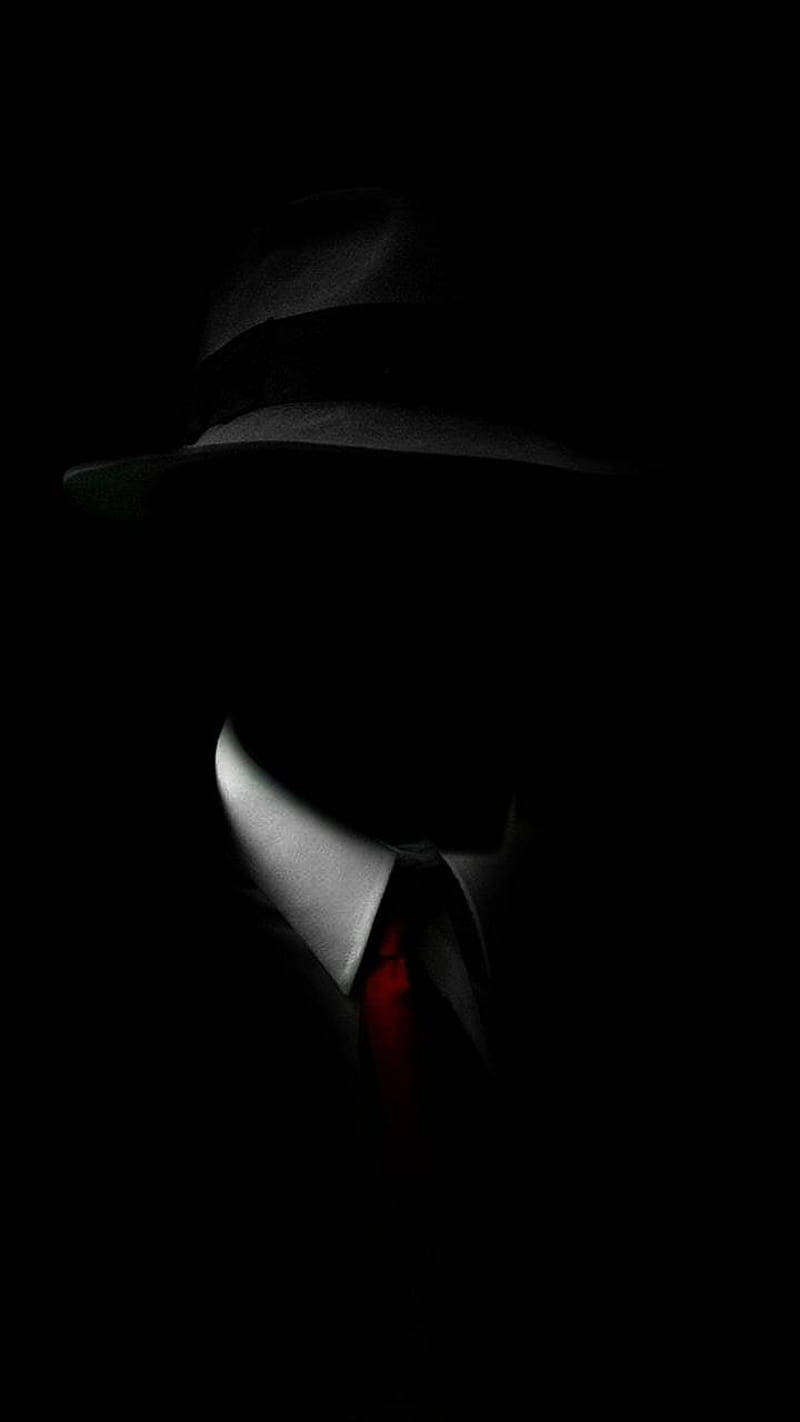 En mand med hat og slips i mørket Wallpaper