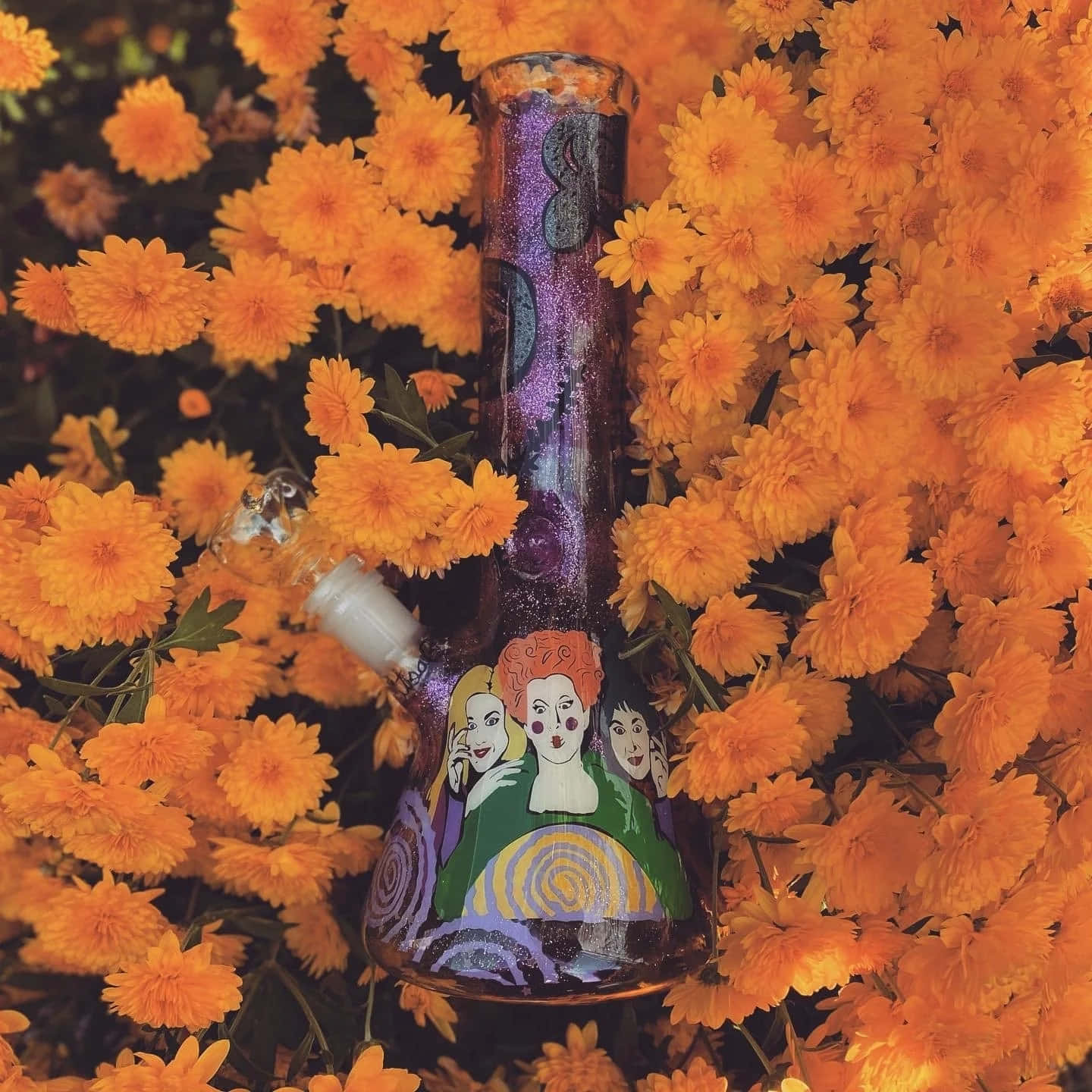 Hocus Pocus Themed Bong Among Orange Flowers Wallpaper