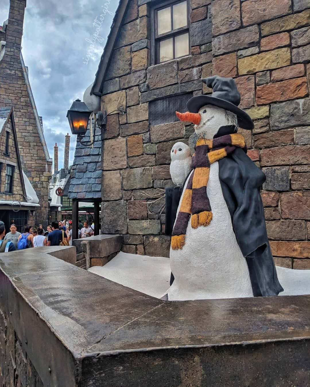 A magical winter evening in Hogsmeade Village Wallpaper