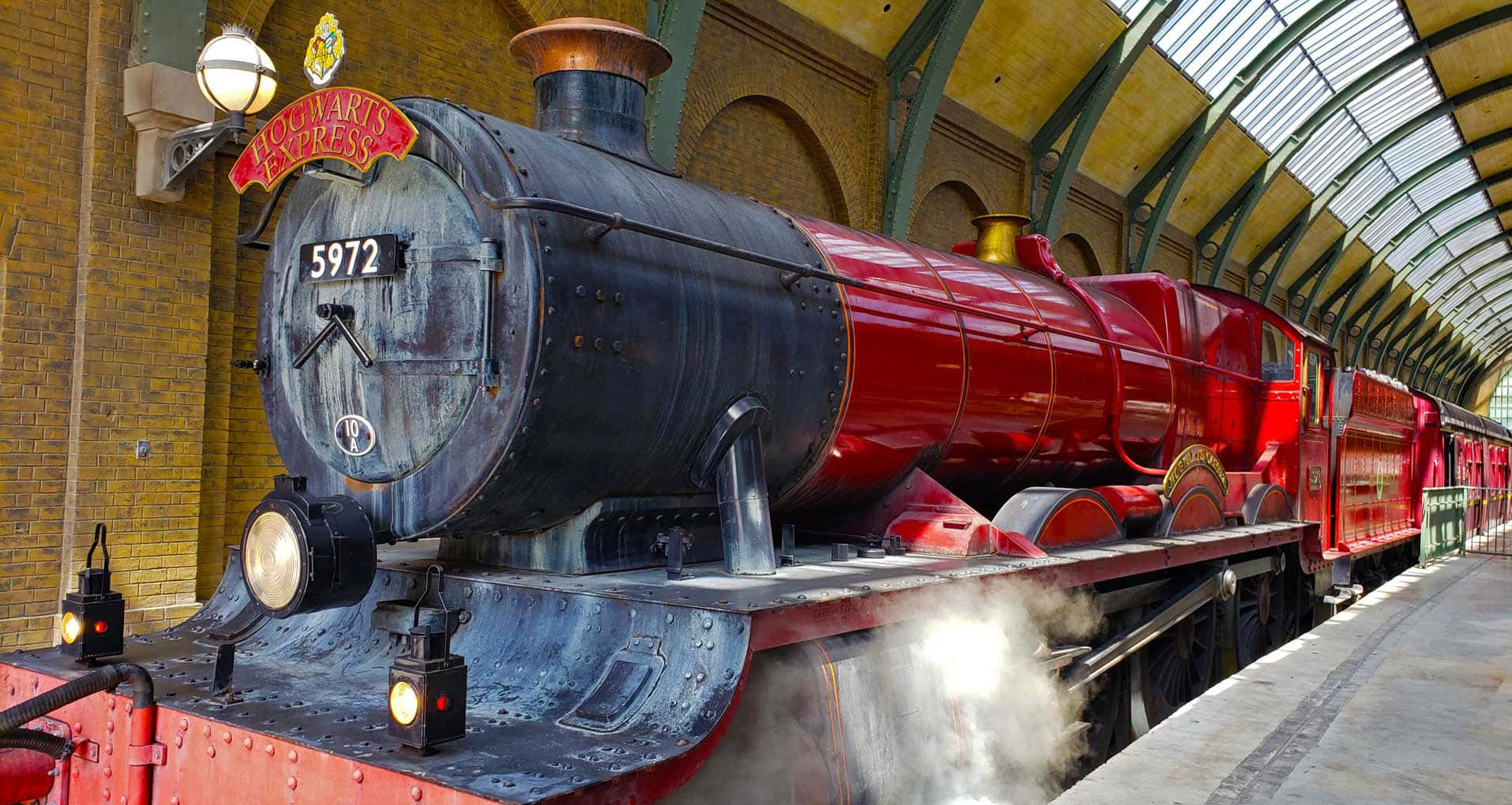 The Iconic Hogwarts Express Train Riding Along a Scenic Route Wallpaper