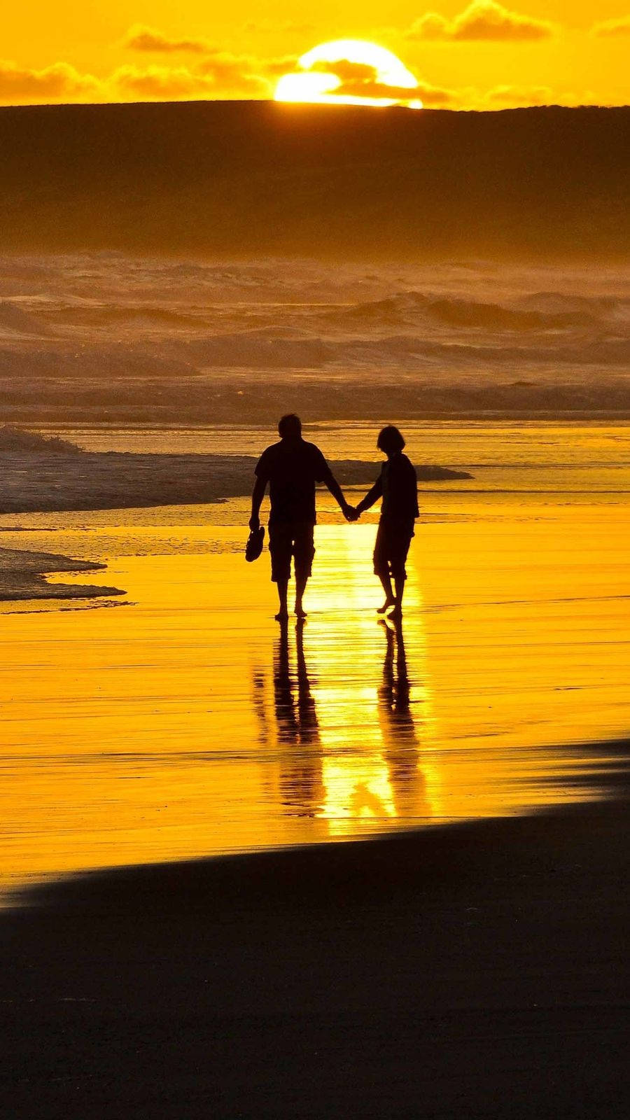 Holding Hands At Sunset On The Beach Wallpaper