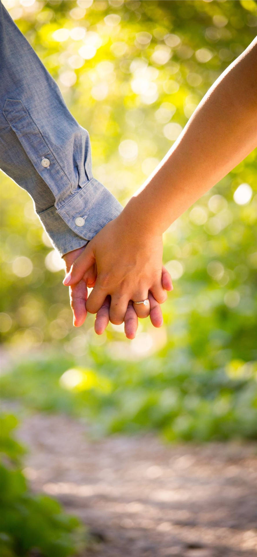 Holding Hands In Green Grass And Leaves Wallpaper