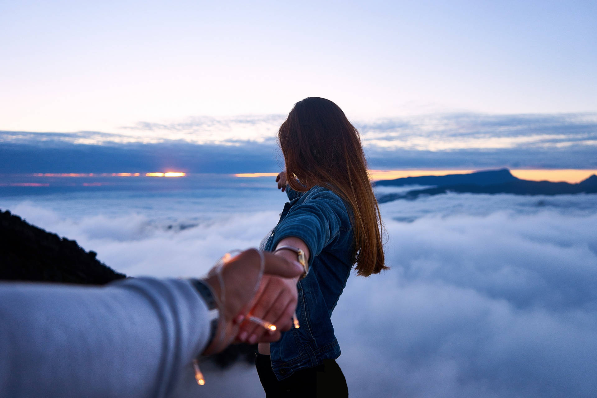 Holding Hands In Sea Of Clouds Wallpaper