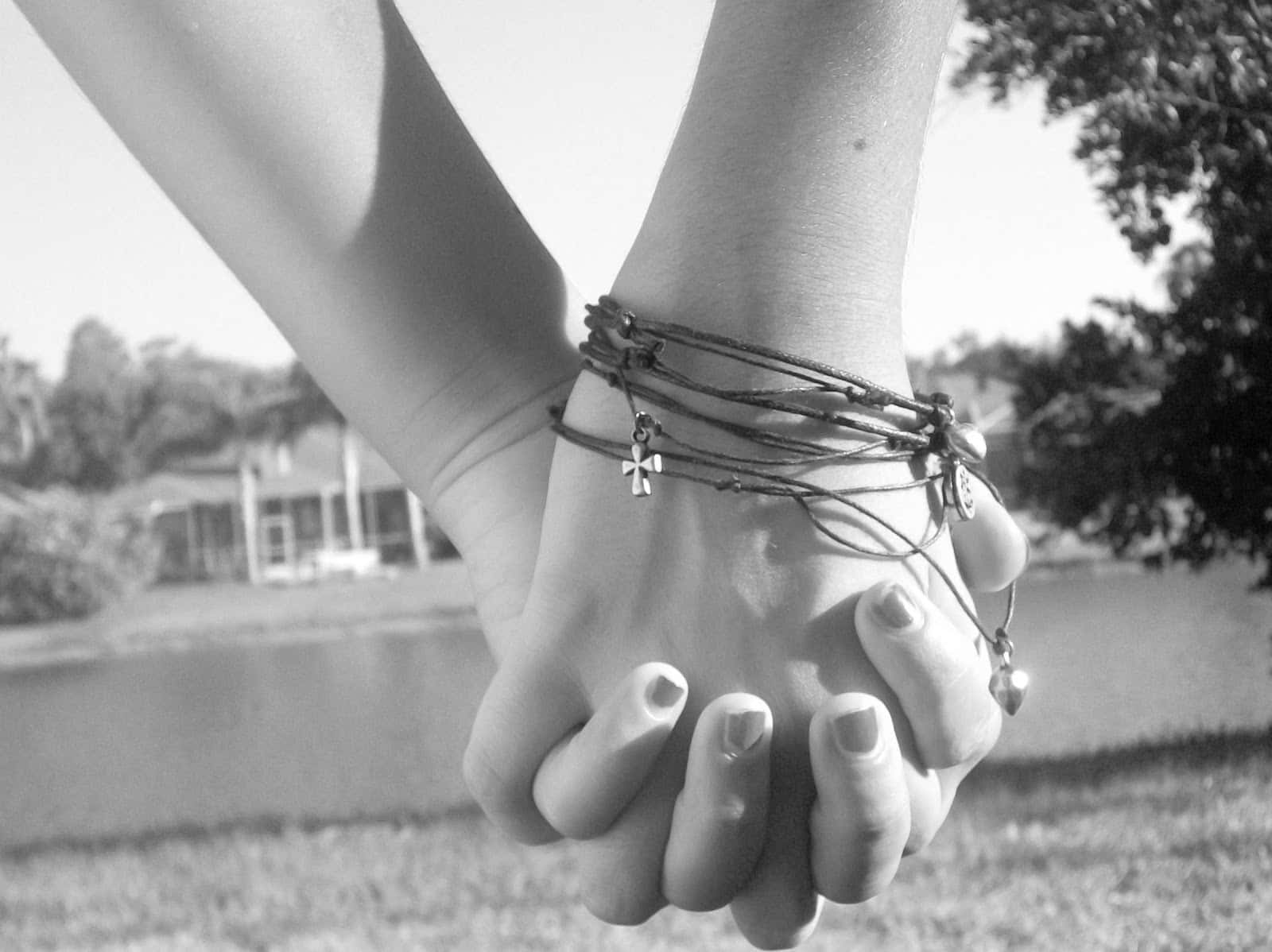 two people holding hands black and white