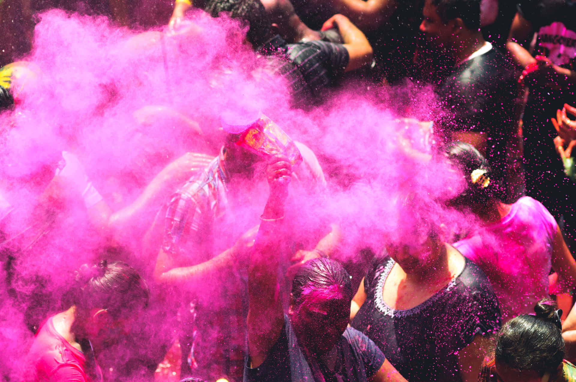 a group of people are throwing pink powder