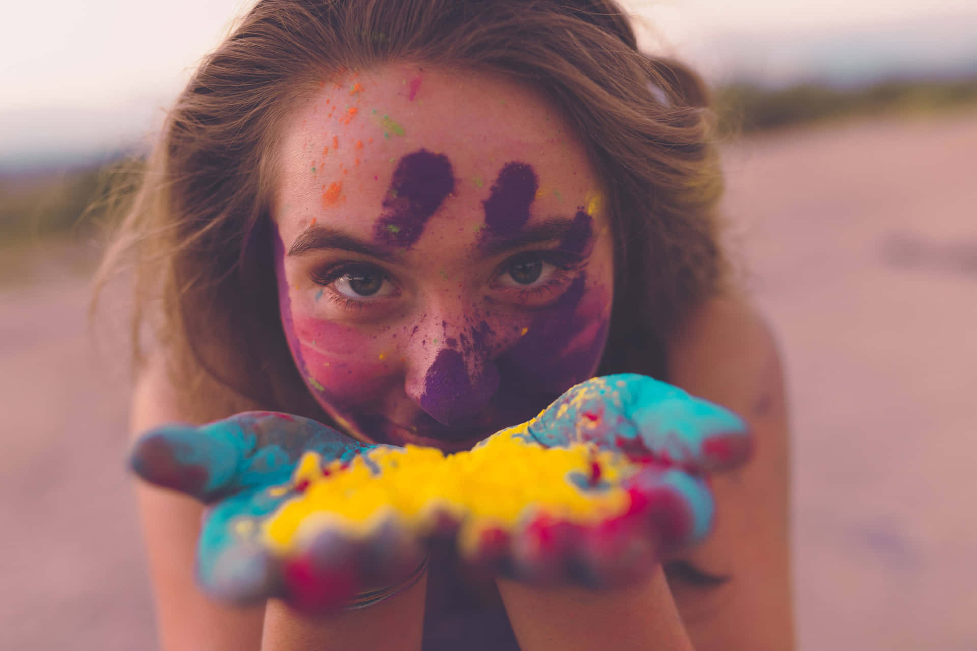 A Girl With Her Hands Covered In Colorful Paint