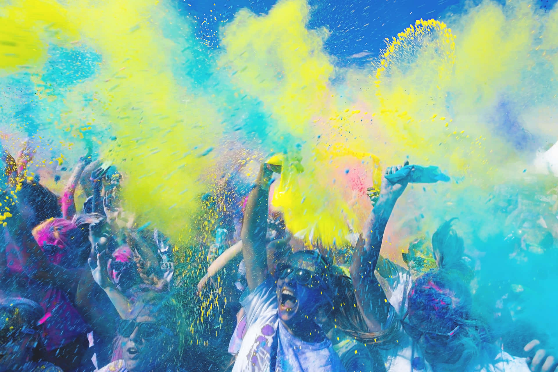 a group of people are throwing colored powder