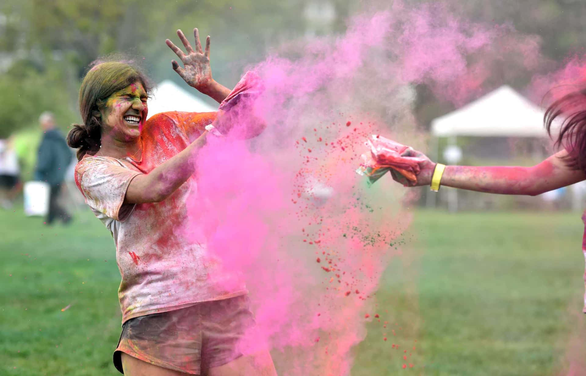 Two Women Are Throwing Pink Powder At Each Other