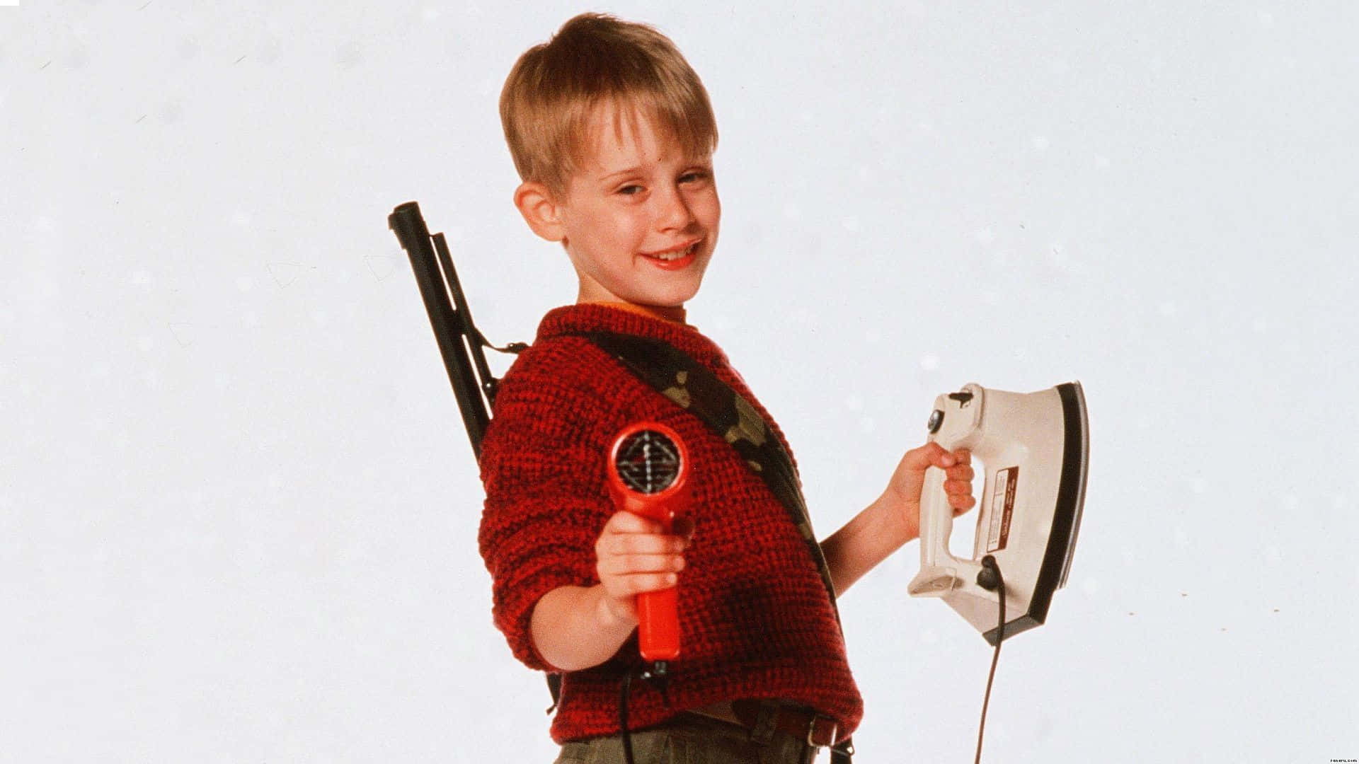 A Young Boy Holding An Iron And A Gun