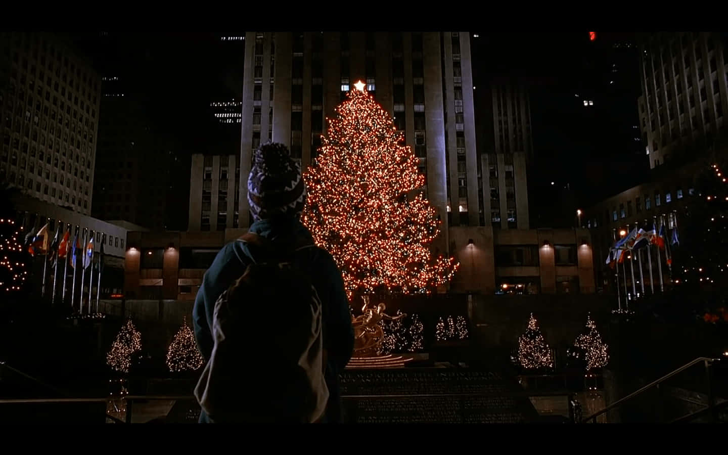 A Man Is Standing In Front Of A Christmas Tree