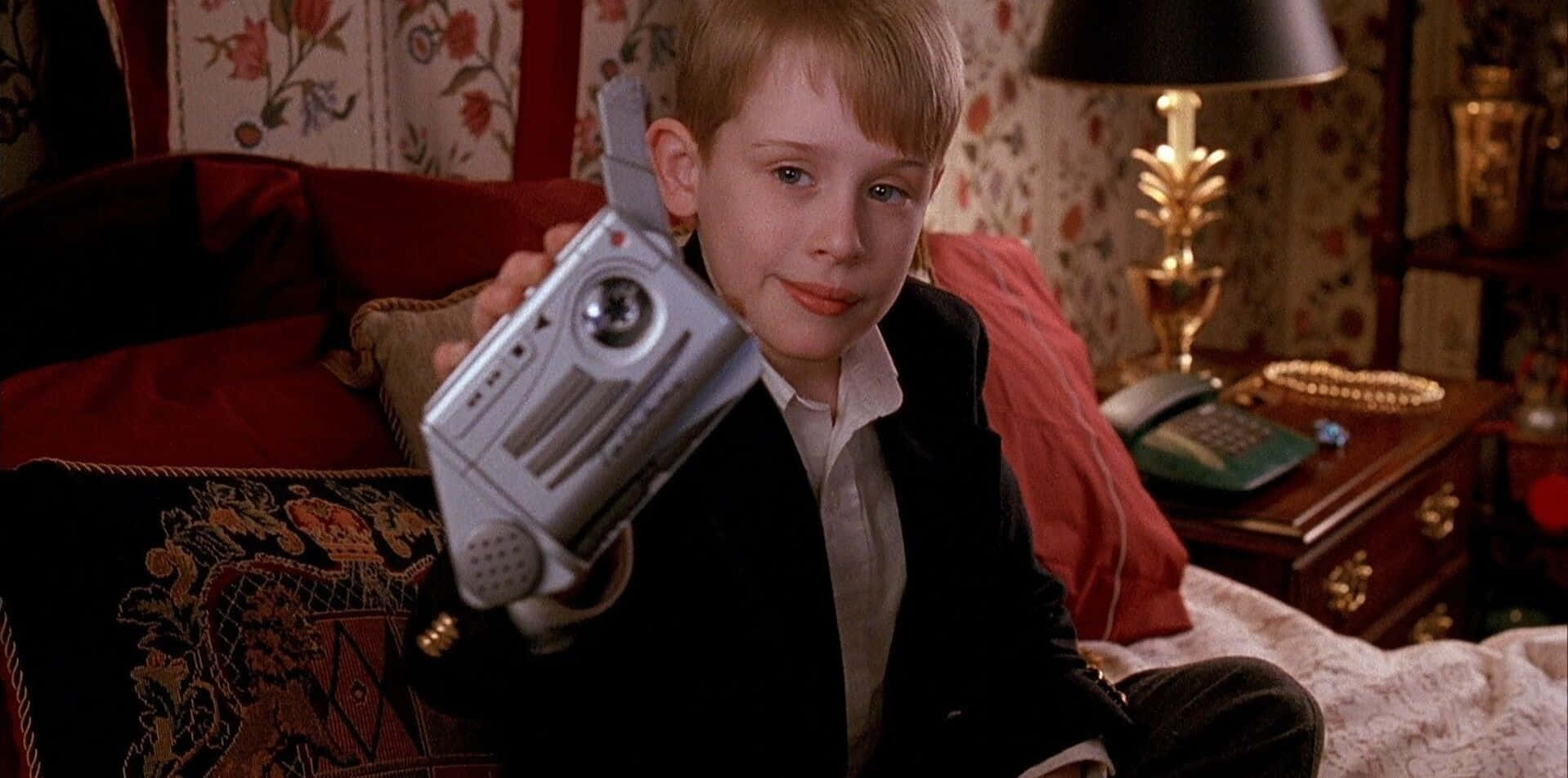 A Young Boy Holding A Remote Control In His Hands