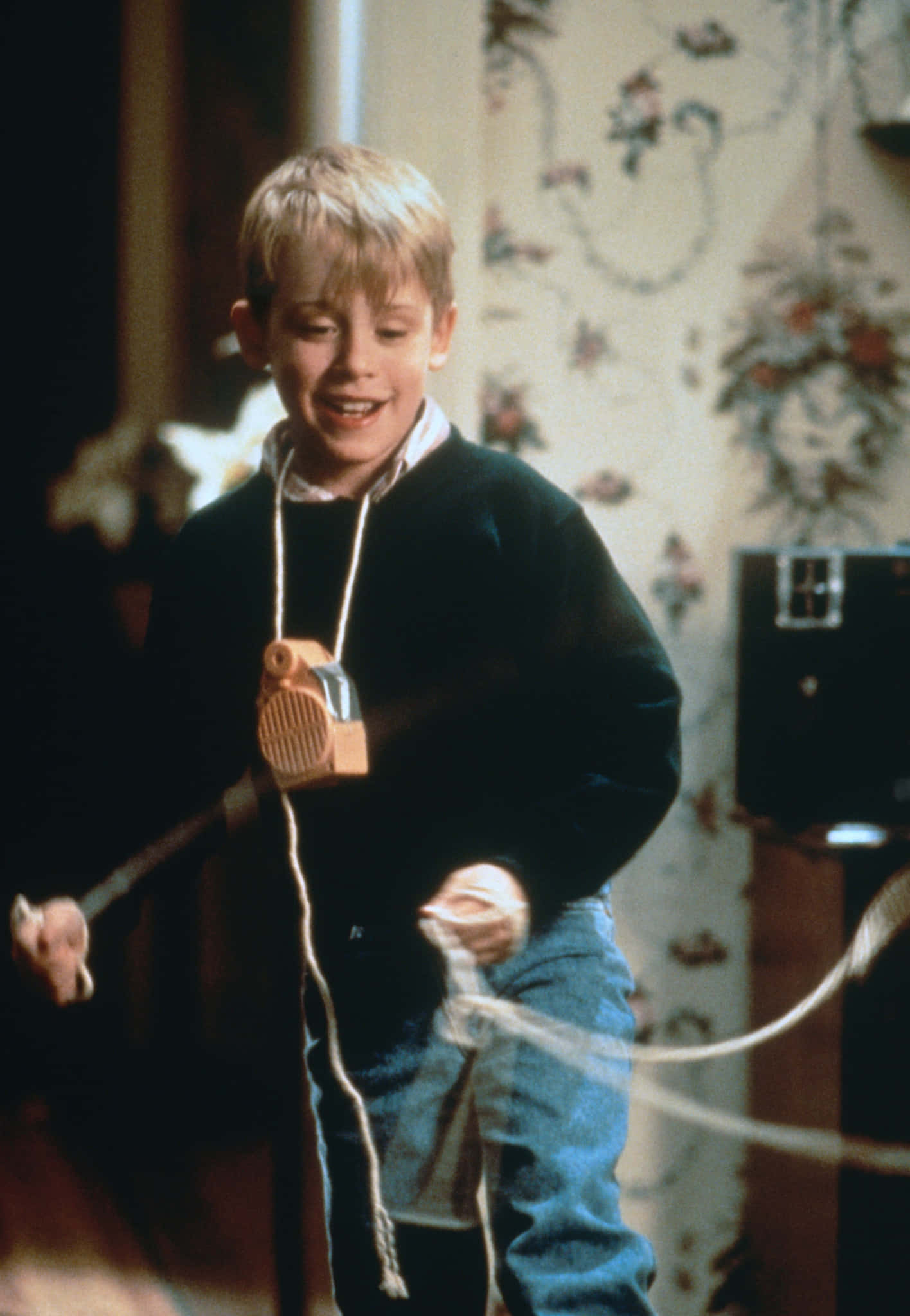 Eight-year-old Kevin McCallister (Macaulay Culkin) dons his signature look of wizard robe and tucks his 20 dollar bill in the pocket in Home Alone (1990).