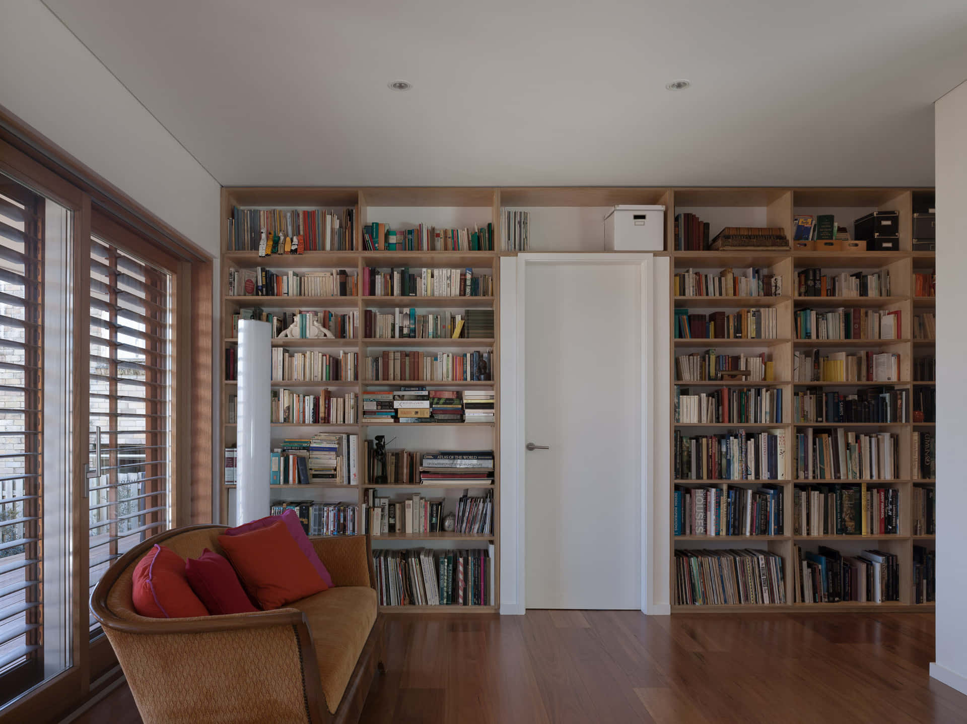Et værelse med en sofa og bogreoler Wallpaper
