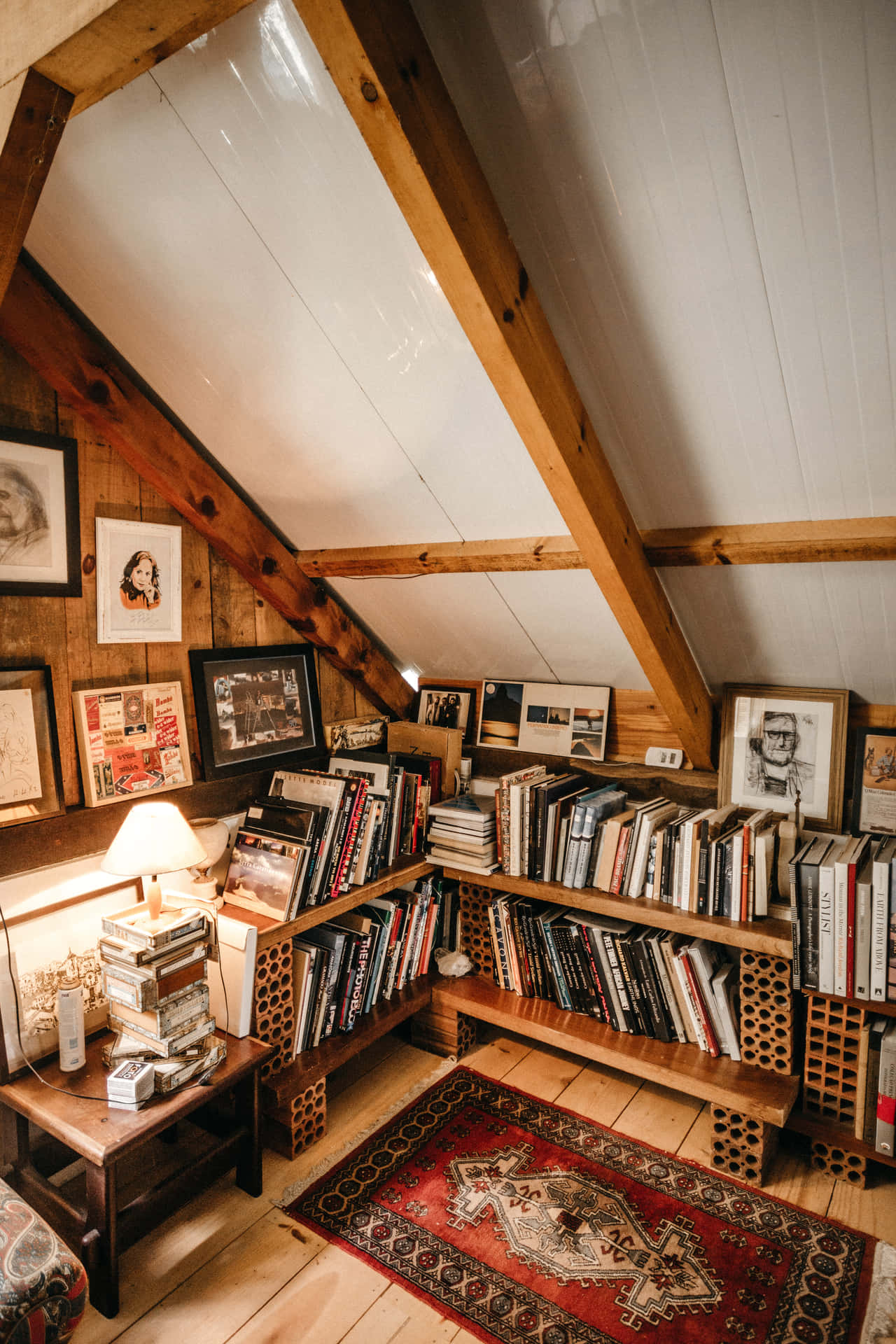 Et værelse med bøger og et tæppe i det. Wallpaper