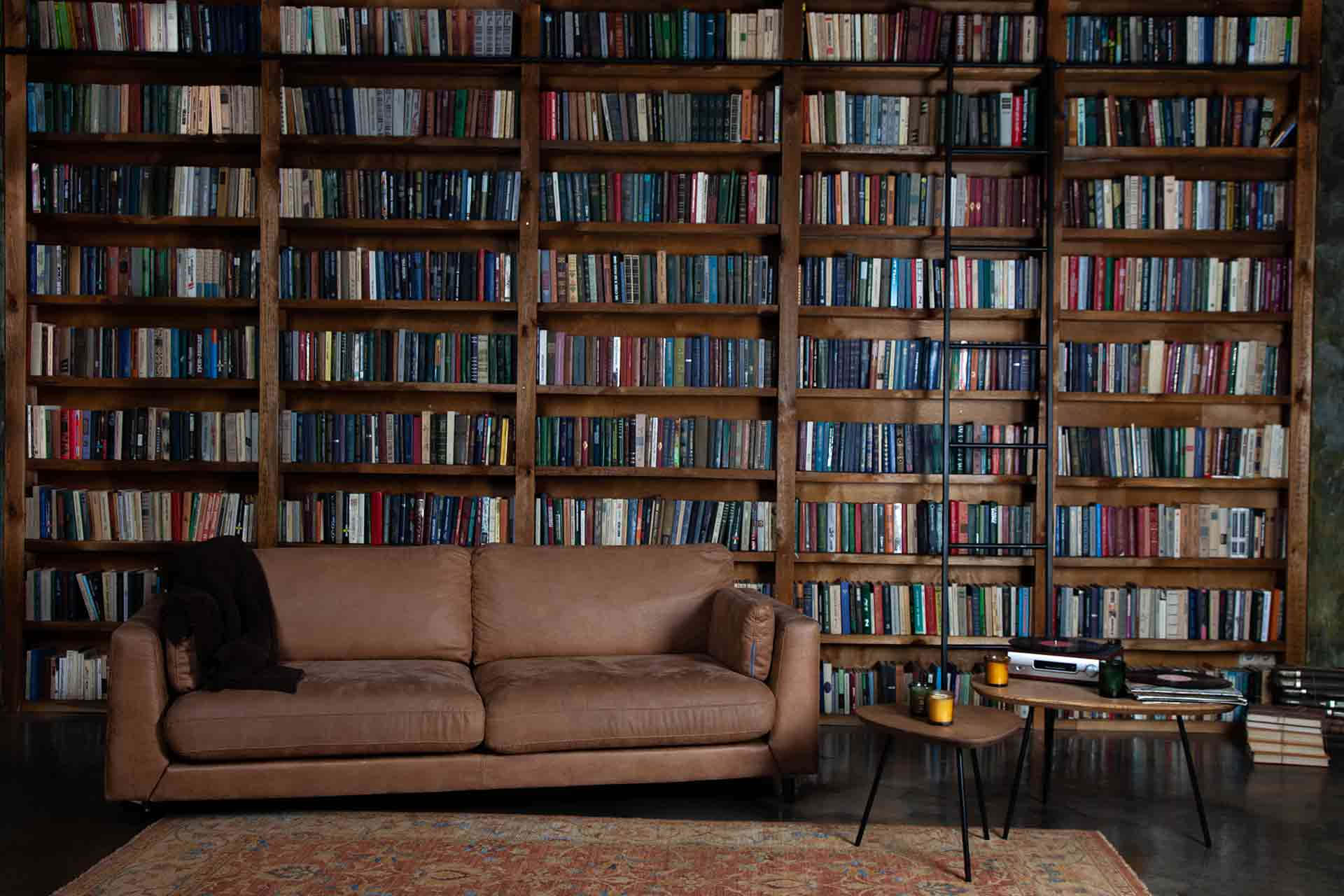 En sofa og et sofabord foran et bogreol Wallpaper