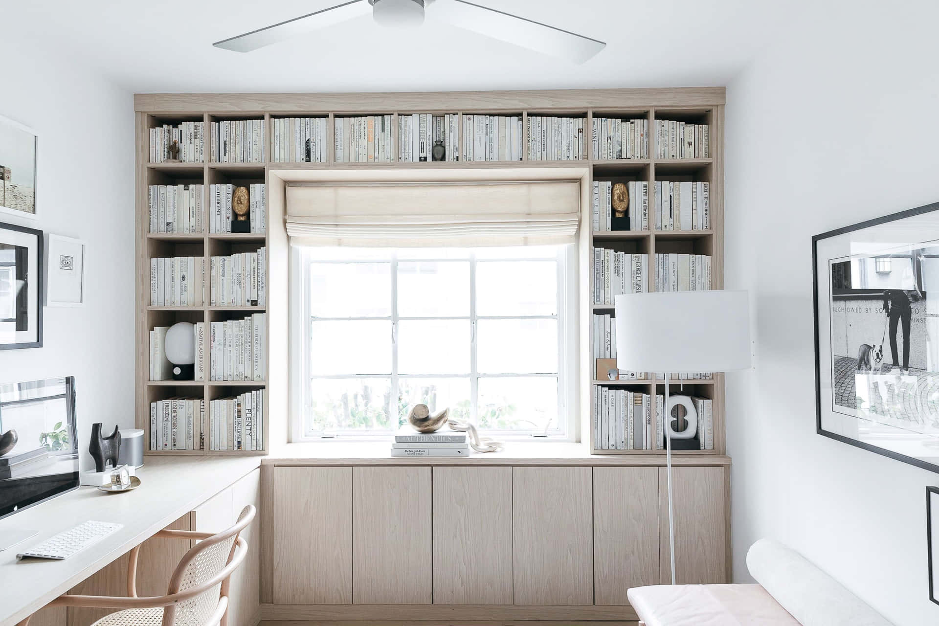 A White And Wood Home Office With A Fan And Bookshelves
