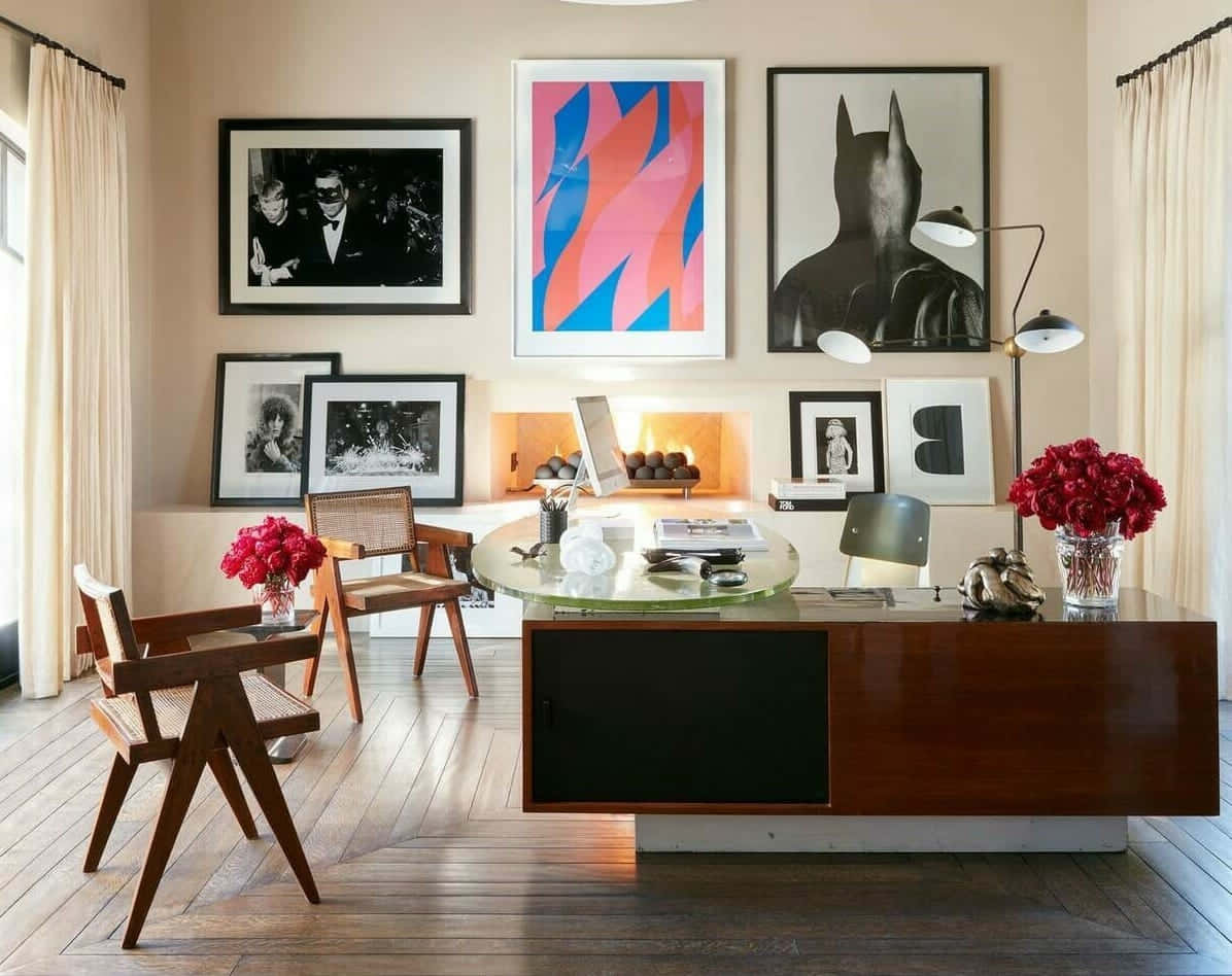 A Home Office With A Desk, Chairs And Framed Pictures