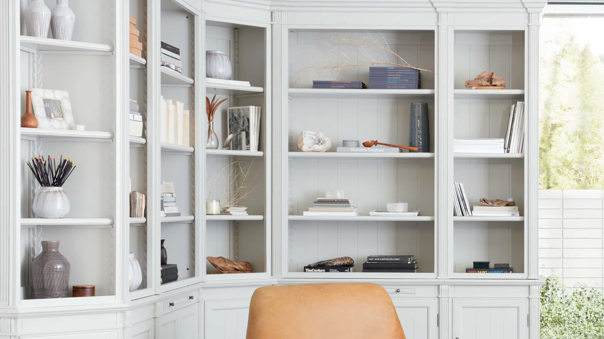 A White Bookcase With A Chair And A Chair