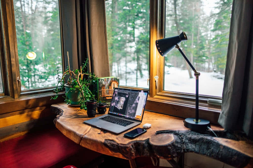 Et skrivebord med en bærbar og en lampe Wallpaper