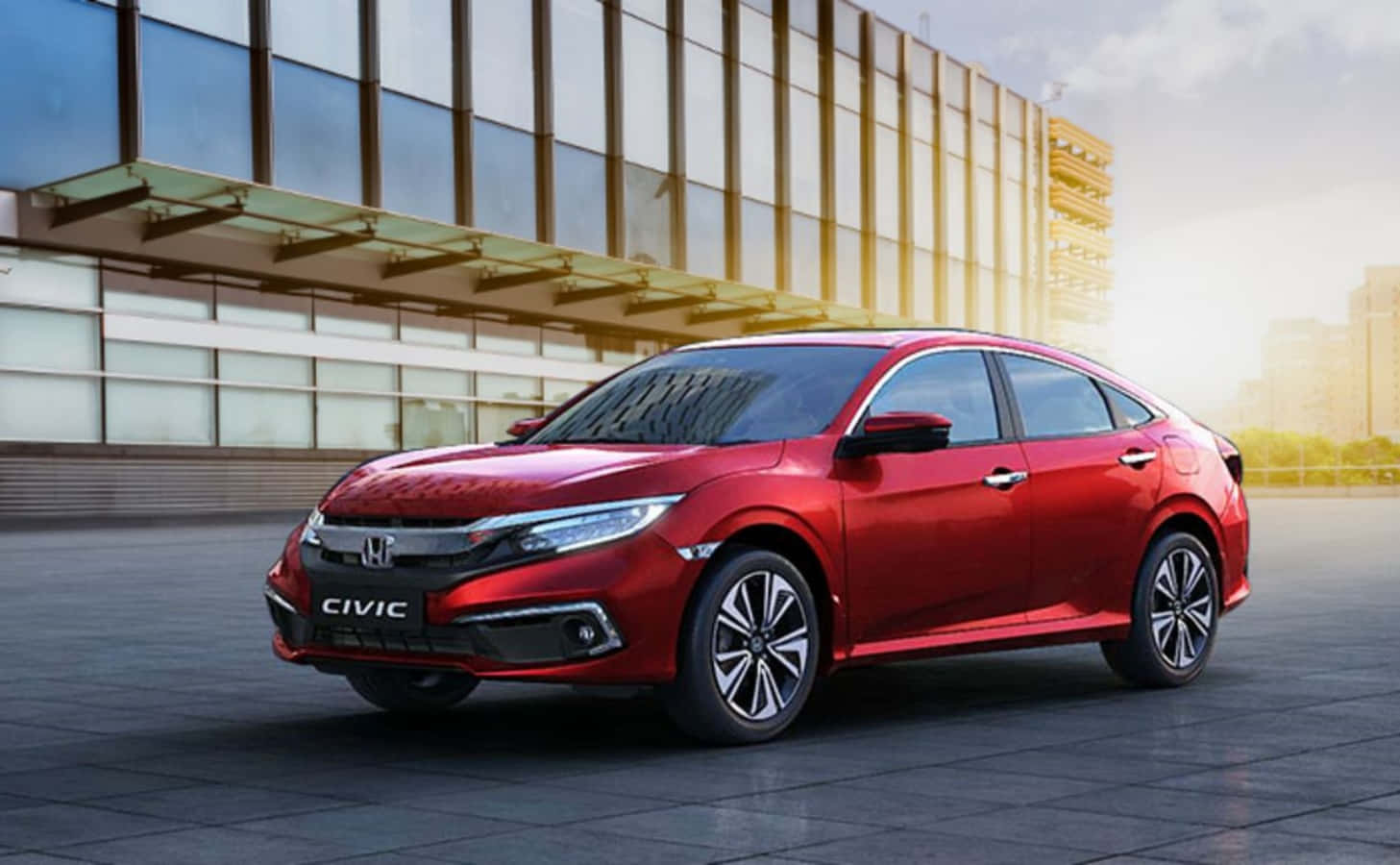 The Red 2019 Honda Civic Sedan Is Parked In Front Of A Building