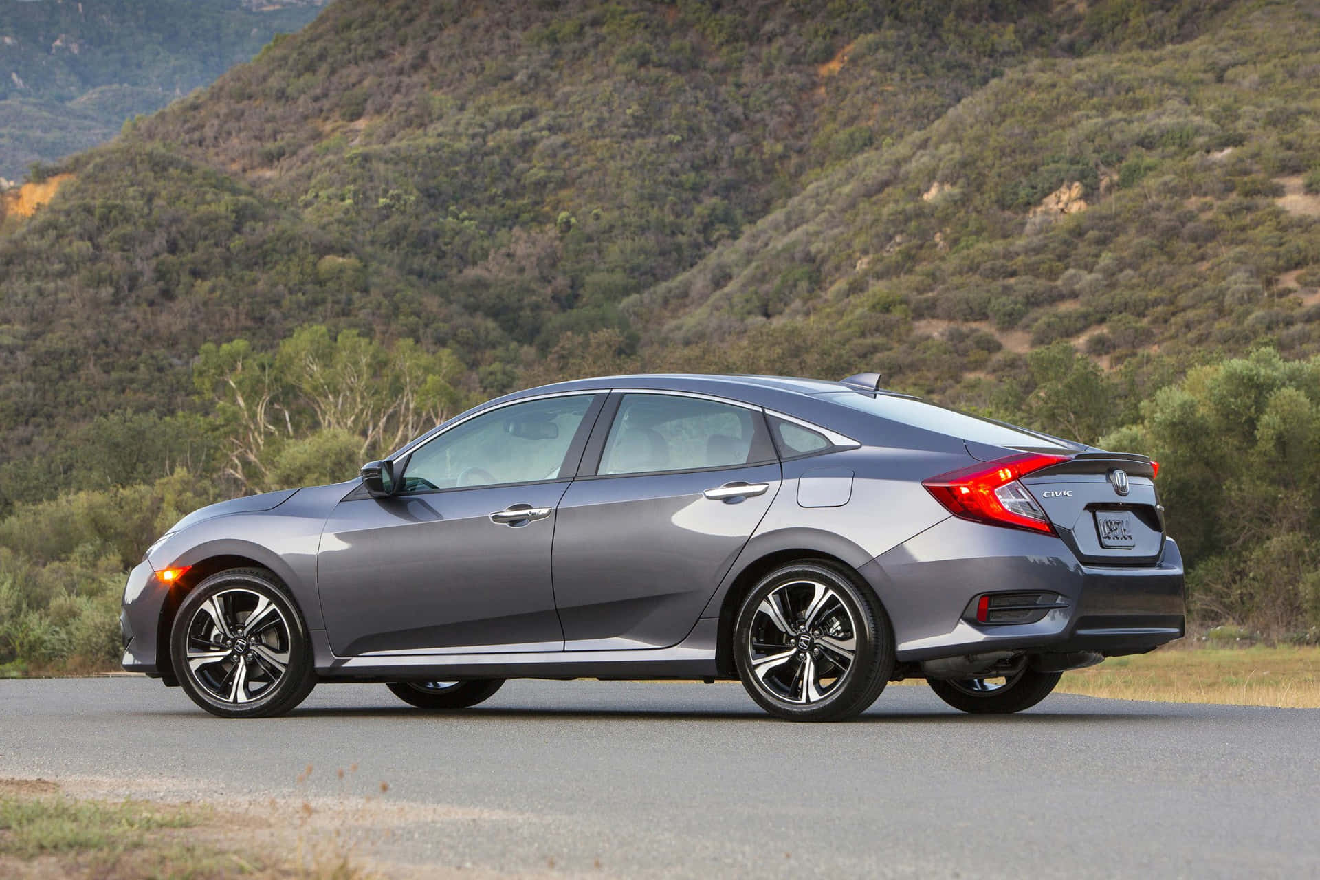 The 2017 Honda Civic Sedan Is Driving Down A Country Road