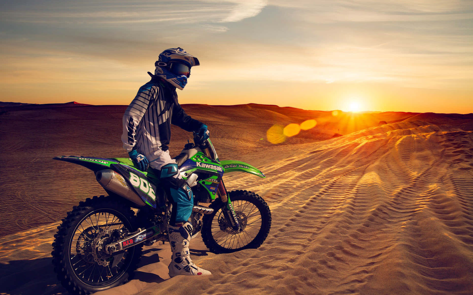 A Man Riding A Dirt Bike In The Desert Wallpaper