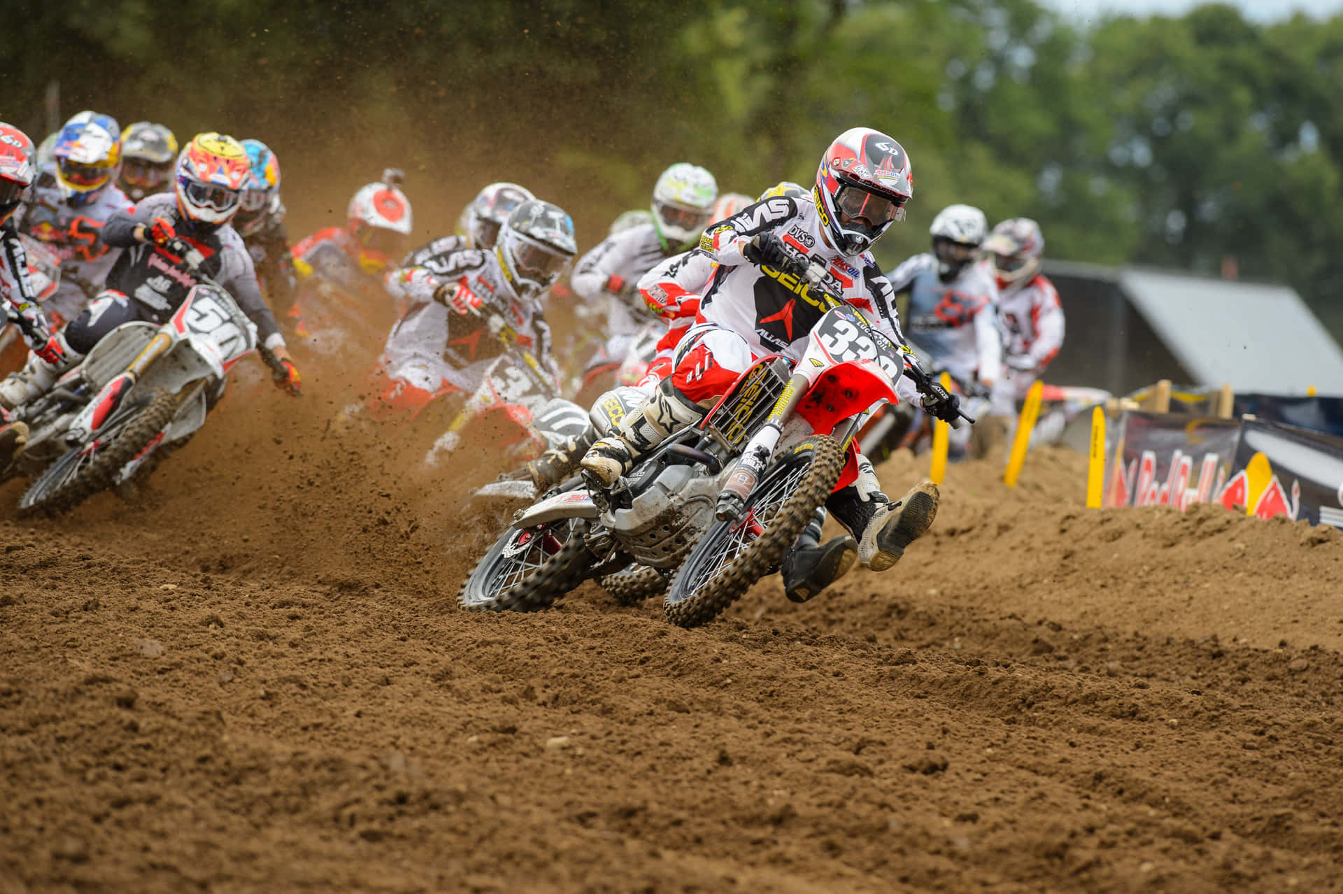 A Group Of Dirt Bikers Racing On A Dirt Track Wallpaper