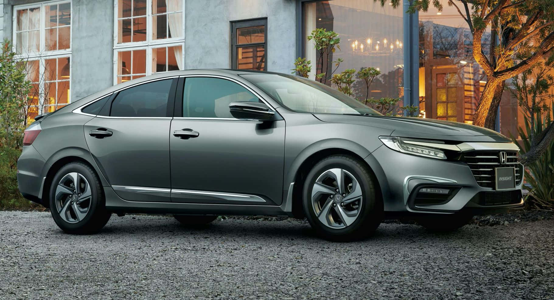 Sleek and stylish Honda Insight Hybrid driving through an urban landscape Wallpaper