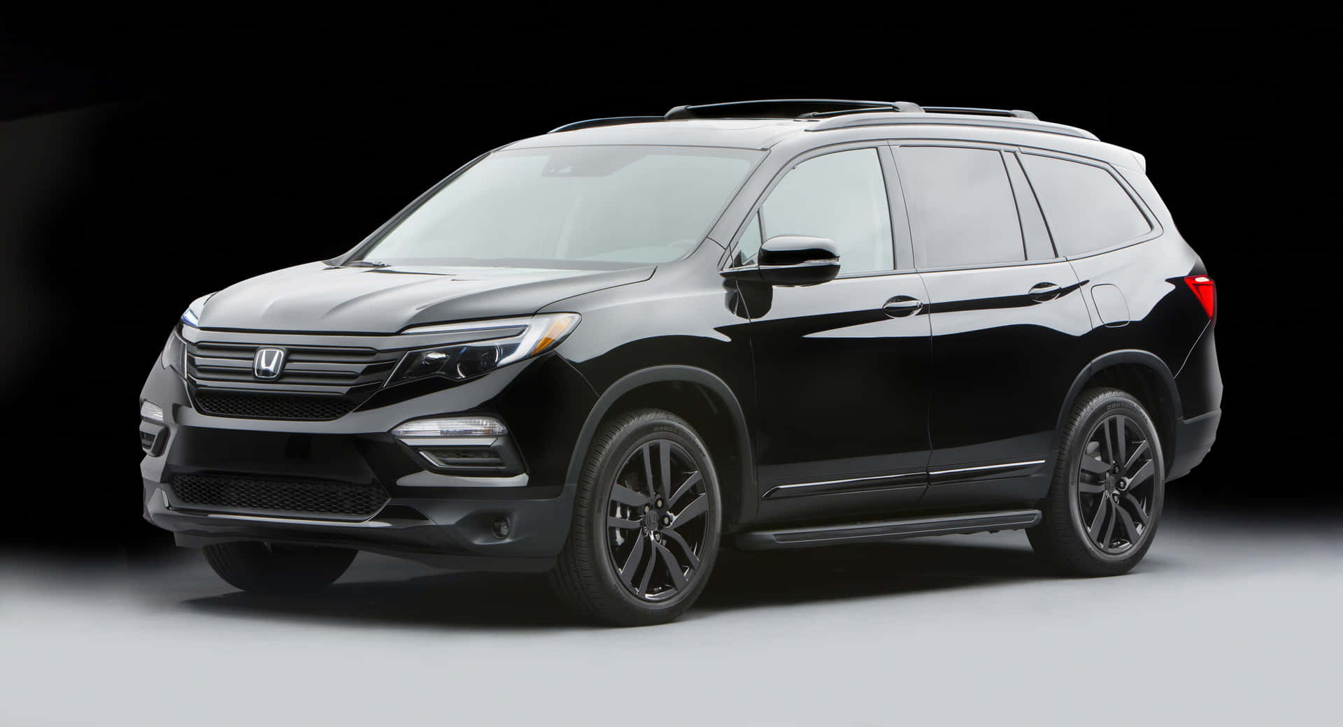 Sleek and Functional Honda Pilot SUV on a Picturesque Highway Wallpaper