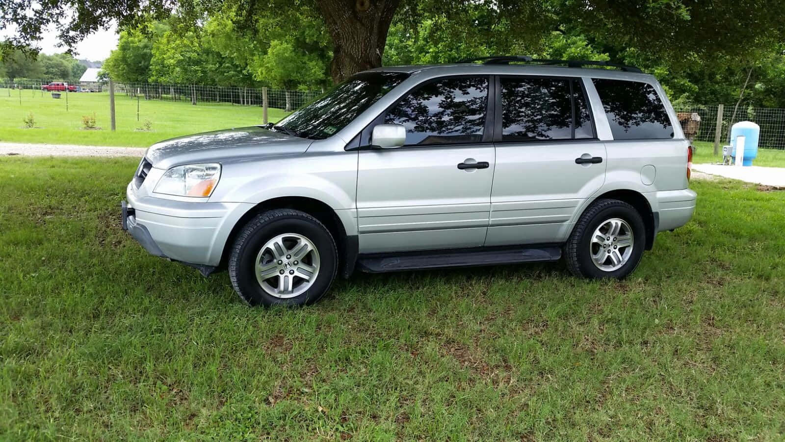 A Silver Suv Is Parked In A Grassy Area