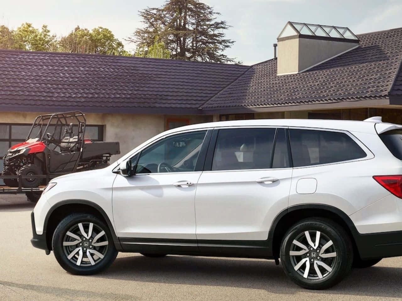 The 2019 Honda Pilot Is Parked In Front Of A House