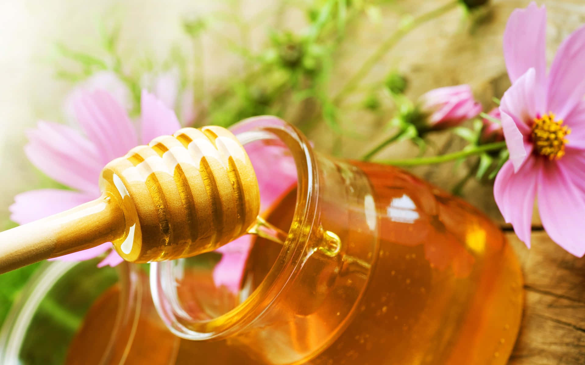Honey Is Being Poured Into A Jar With Flowers