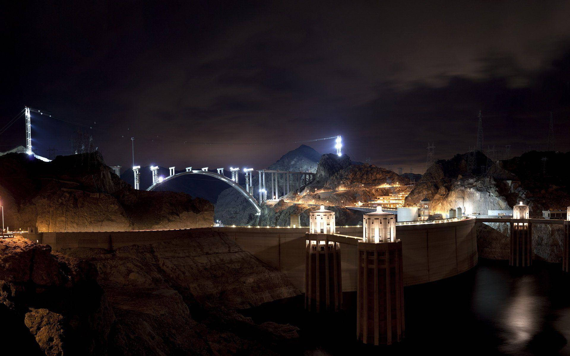 A spellbinding view of the Hoover Dam illuminated at night. Wallpaper