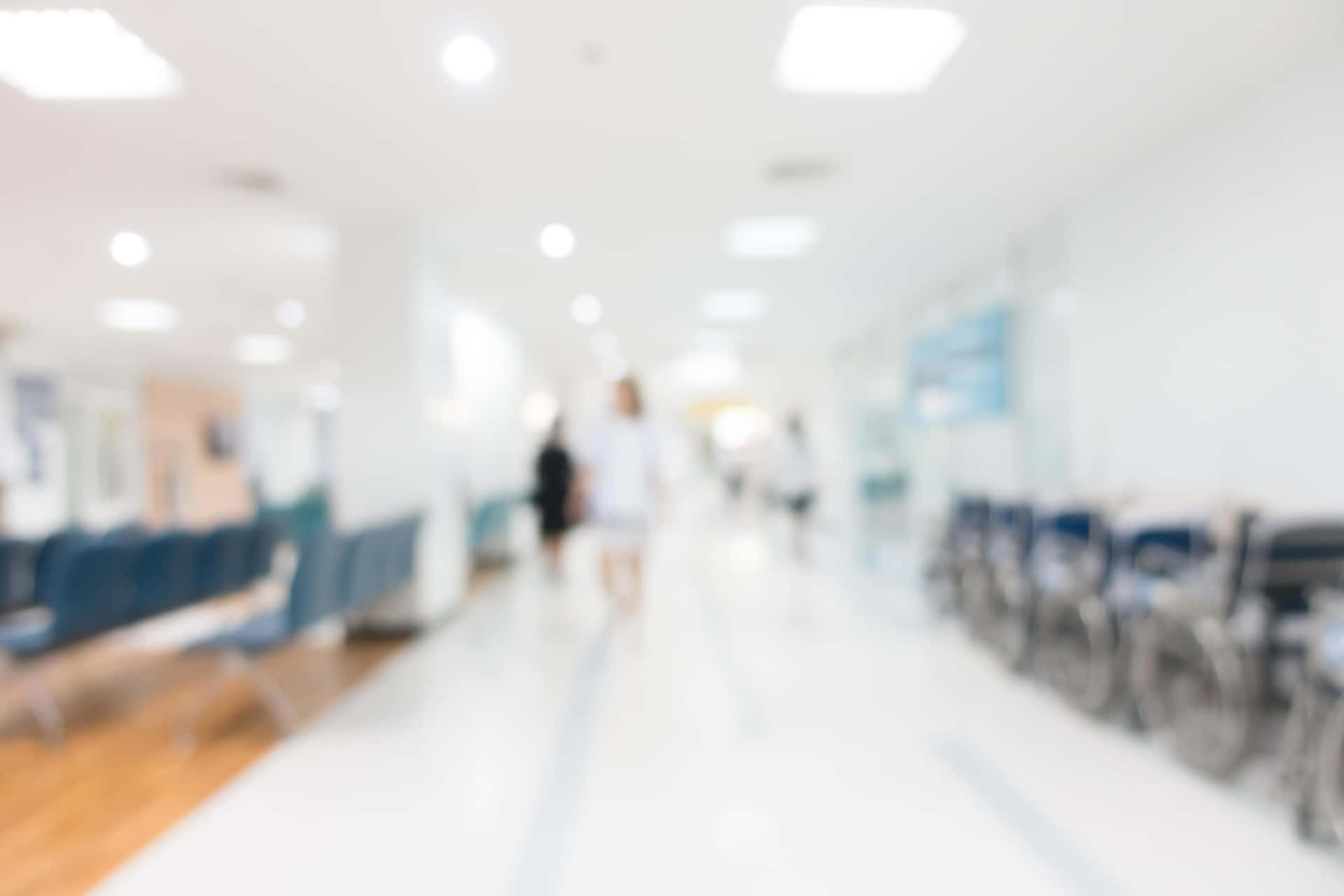 Blurred Image Of A Hospital Hallway With People Walking Down It