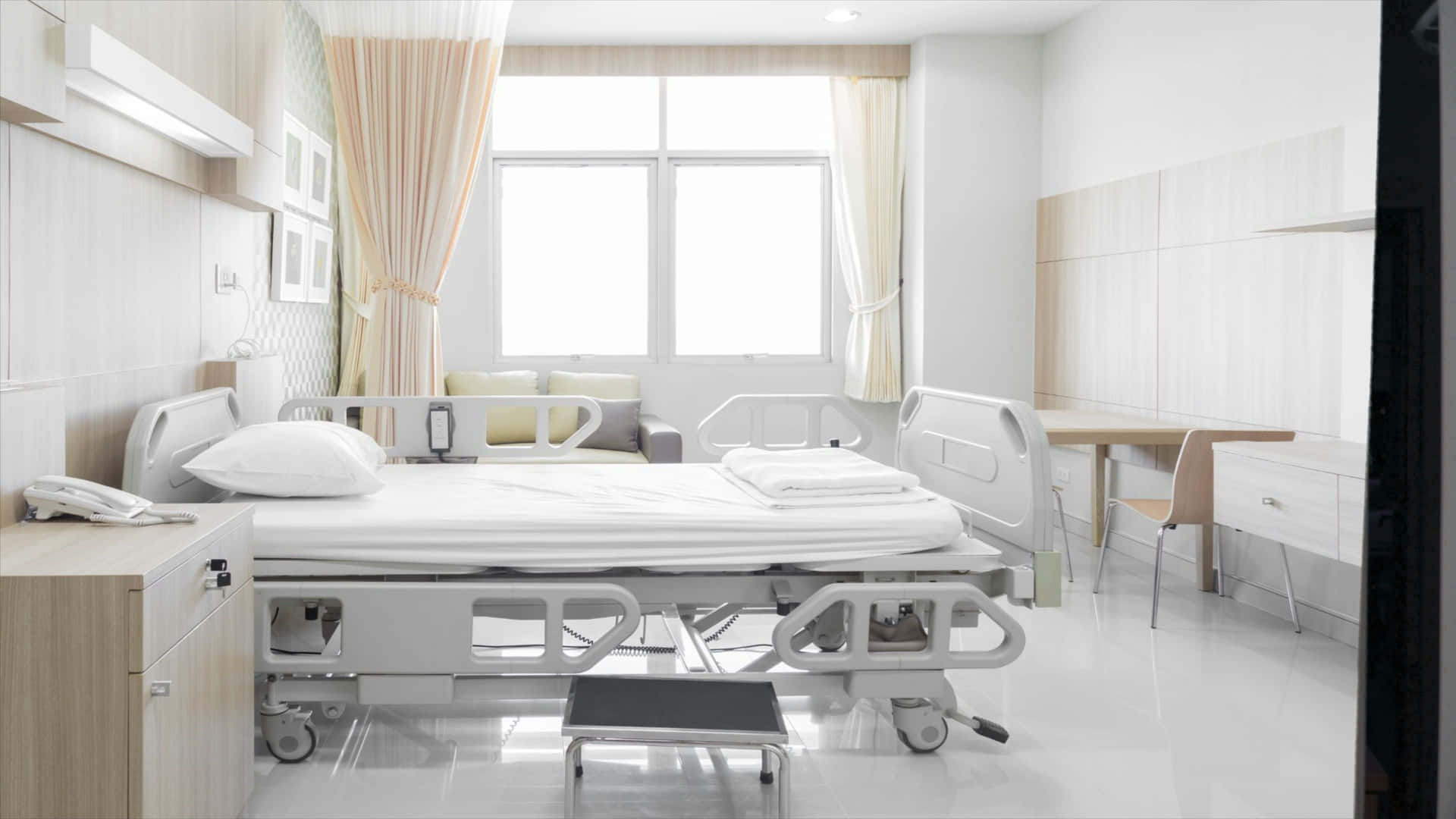 A Hospital Room With A Bed And A Bedside Table