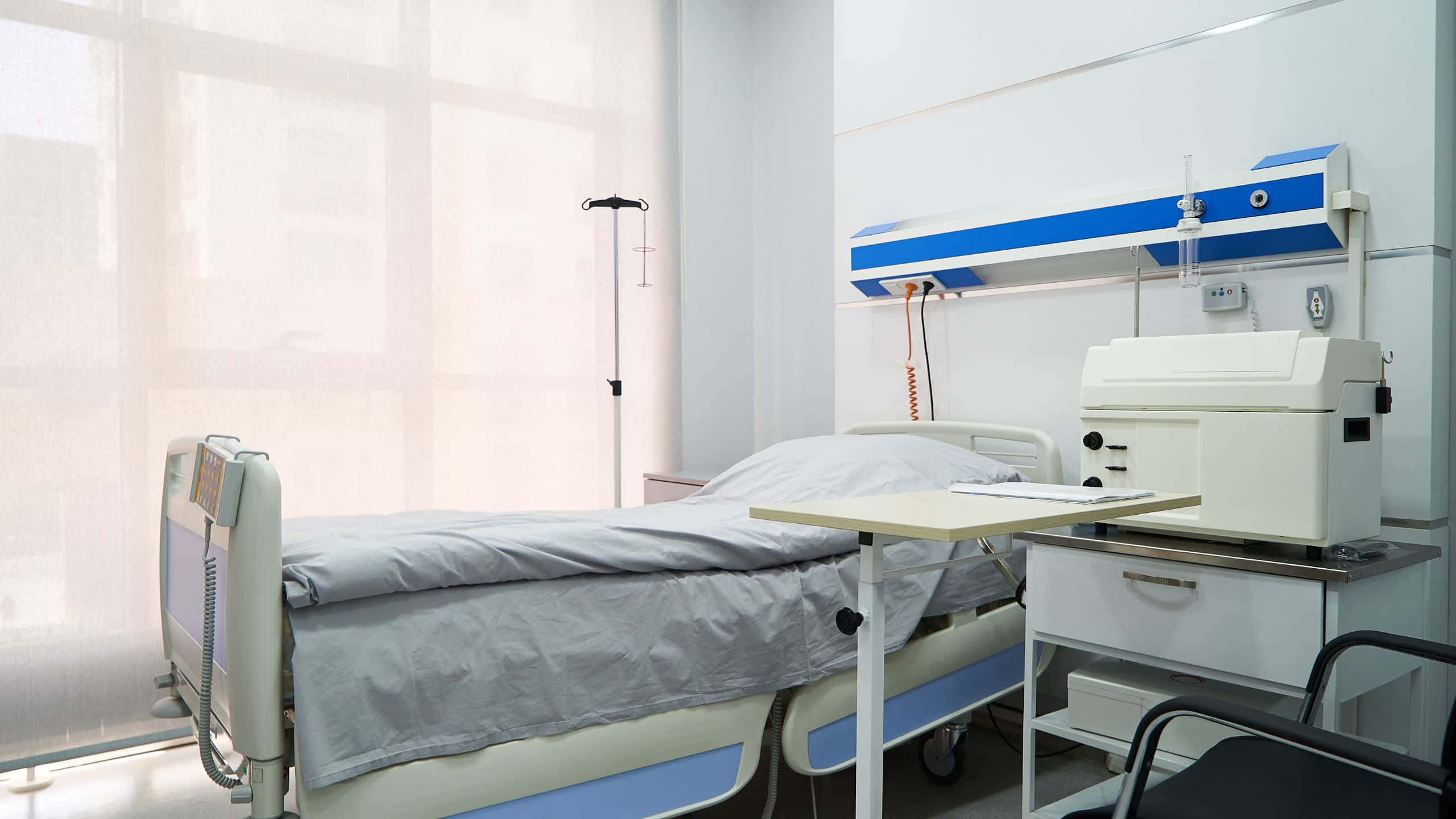 A Hospital Room With A Bed And A Desk