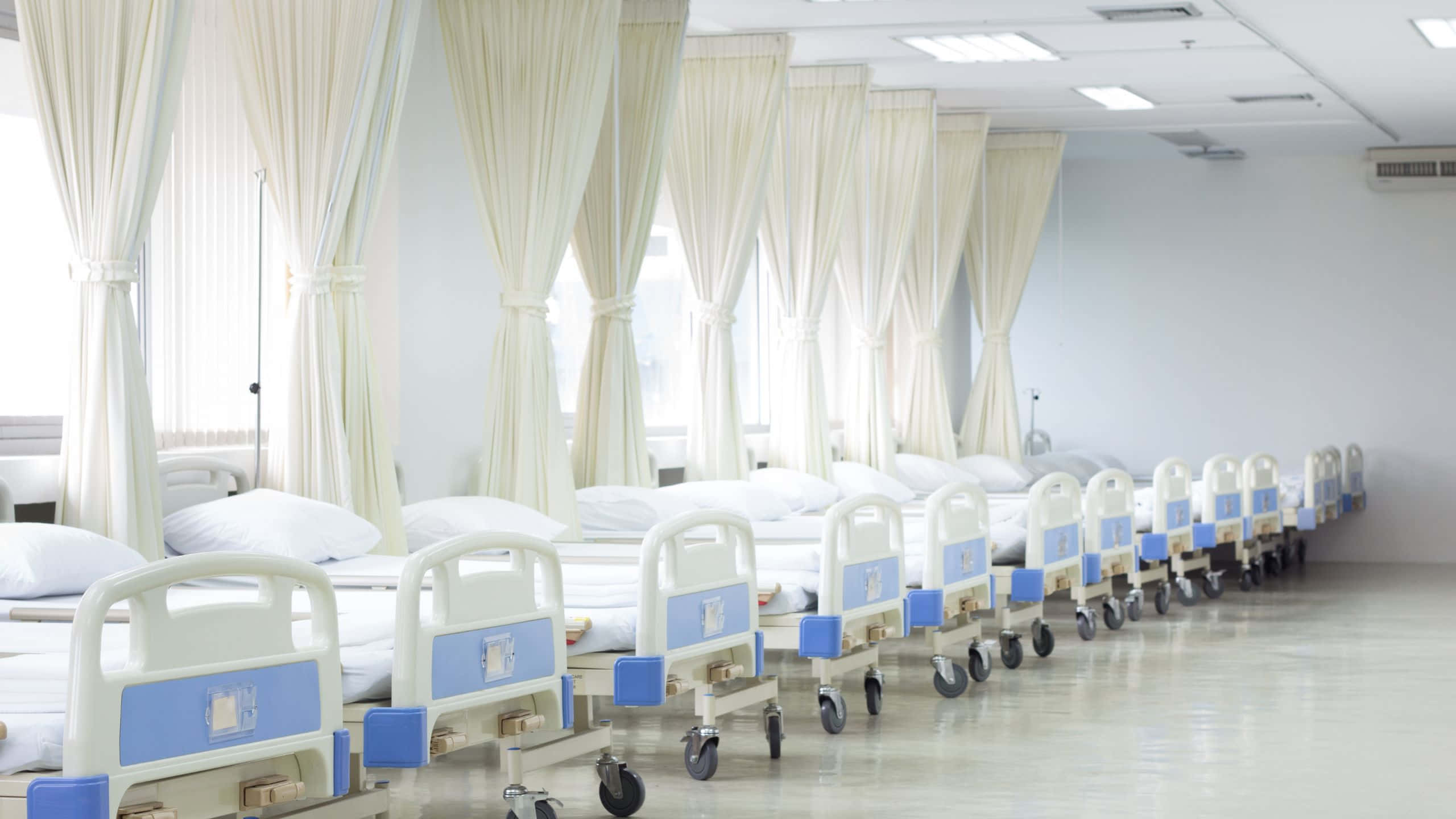 A Row Of Hospital Beds In A Hospital Room