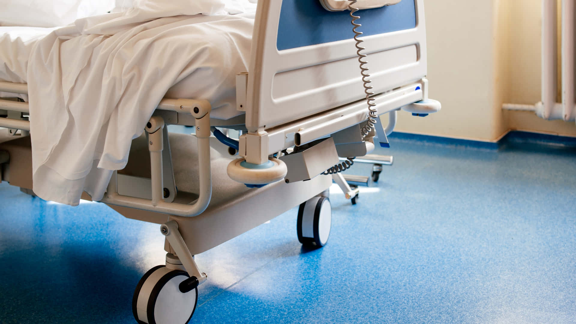 Detailed Close-up of a Modern Hospital Bed with Wheels Wallpaper