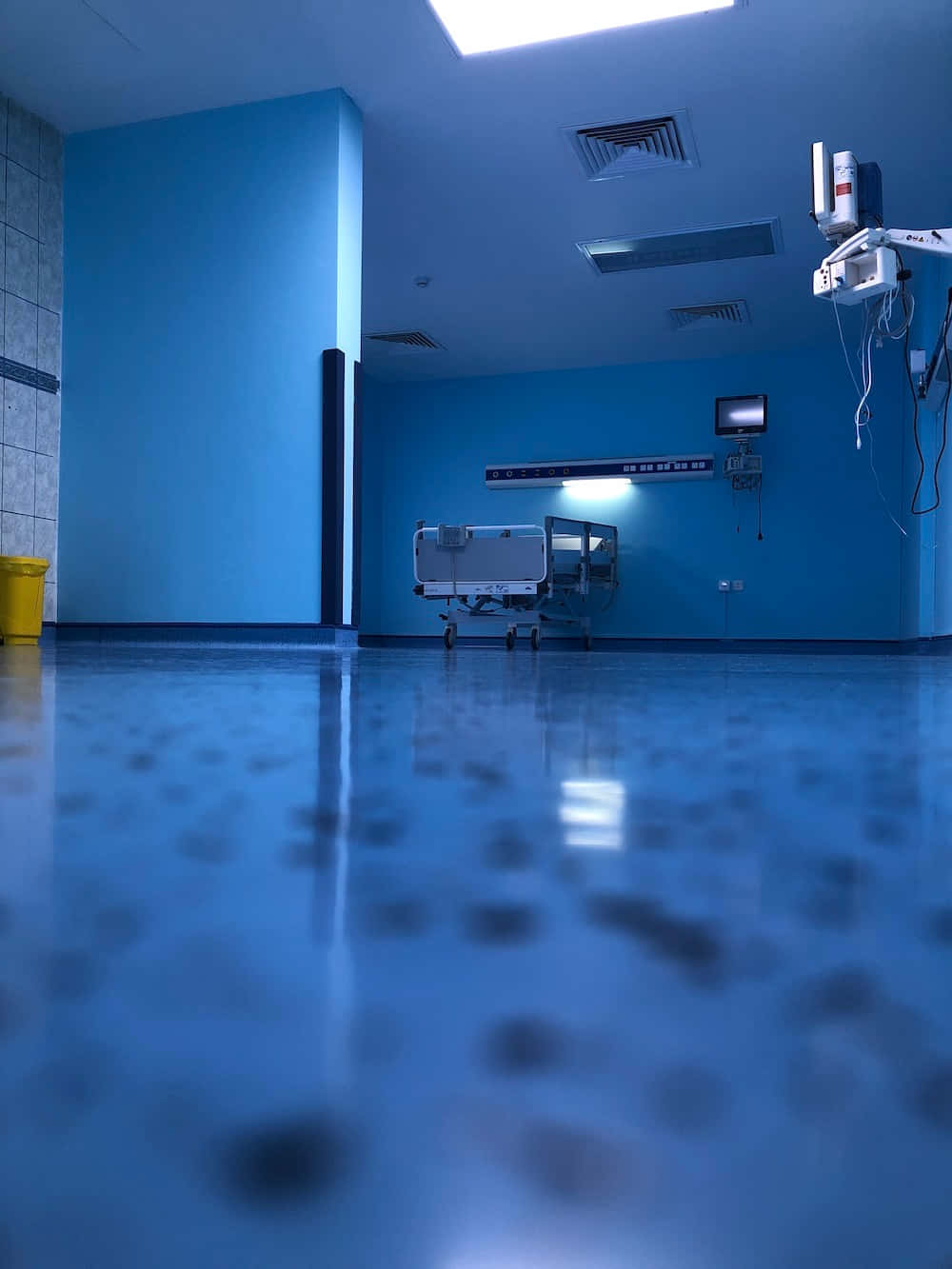 A Hospital Room With Blue Walls And A Bed