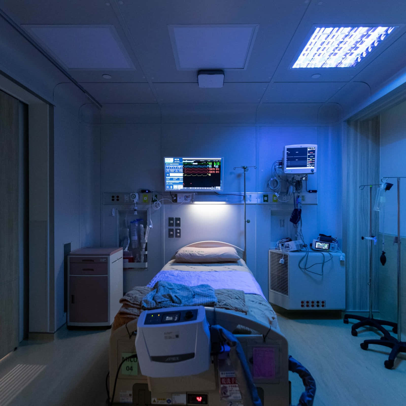 A Hospital Room With A Bed And A Monitor