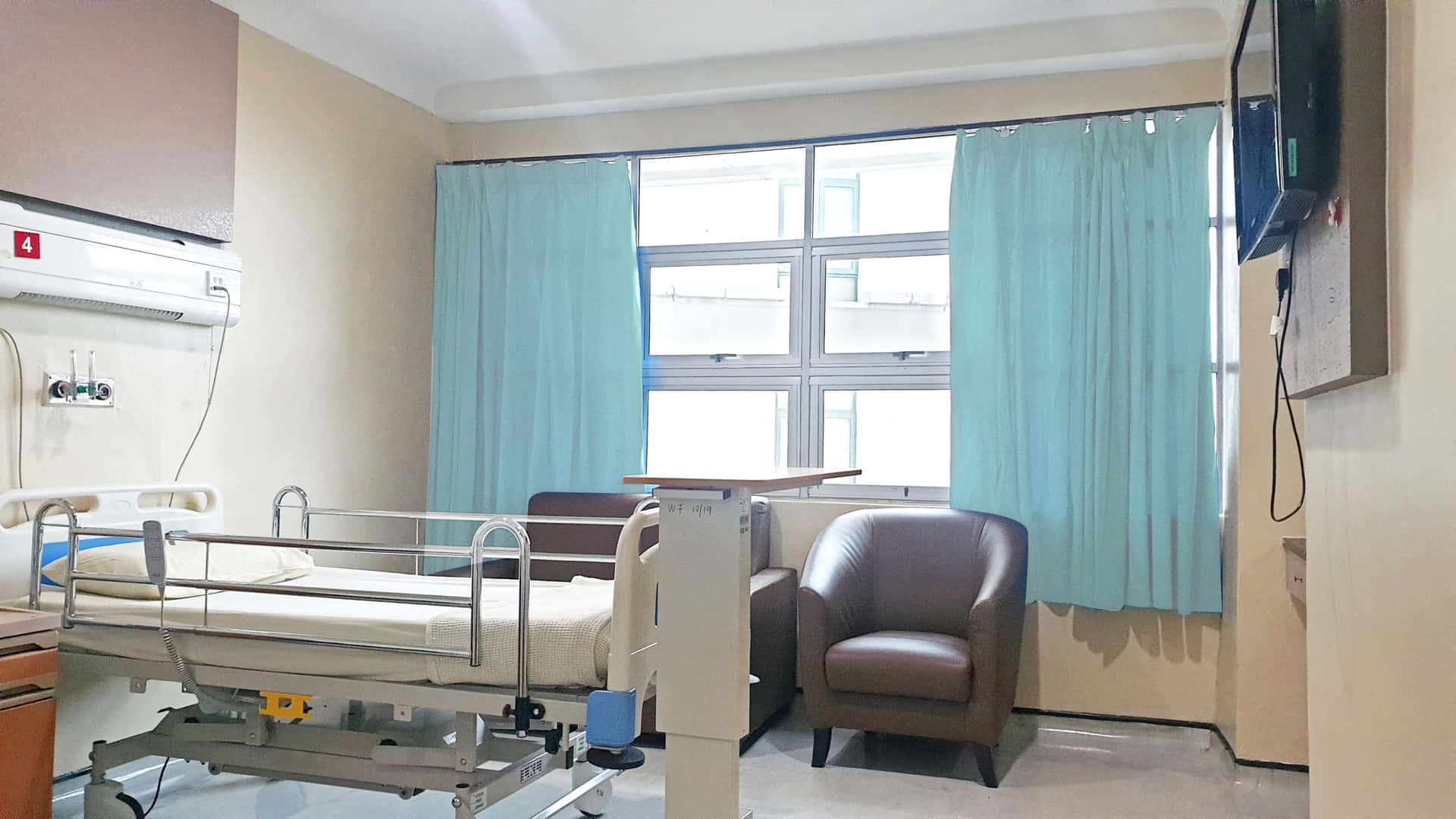 A Hospital Room With A Bed And A Monitor