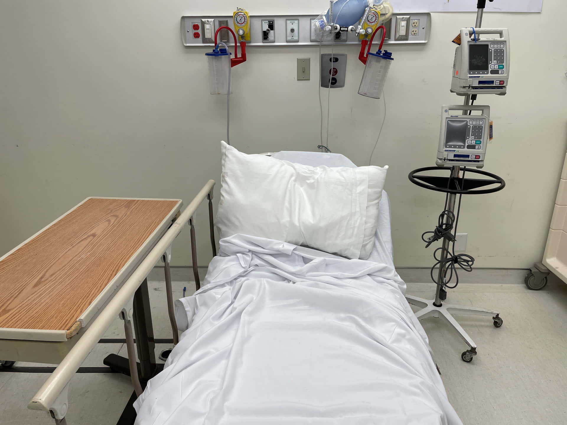 A Hospital Bed With A Monitor And A Bedside Table