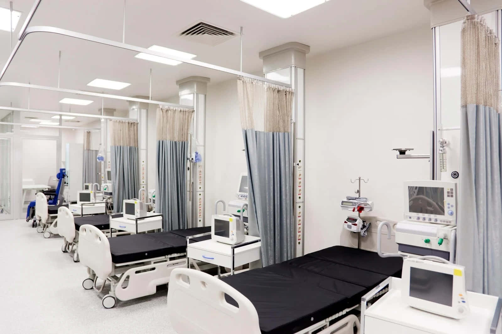 A Hospital Room With Beds And Curtains
