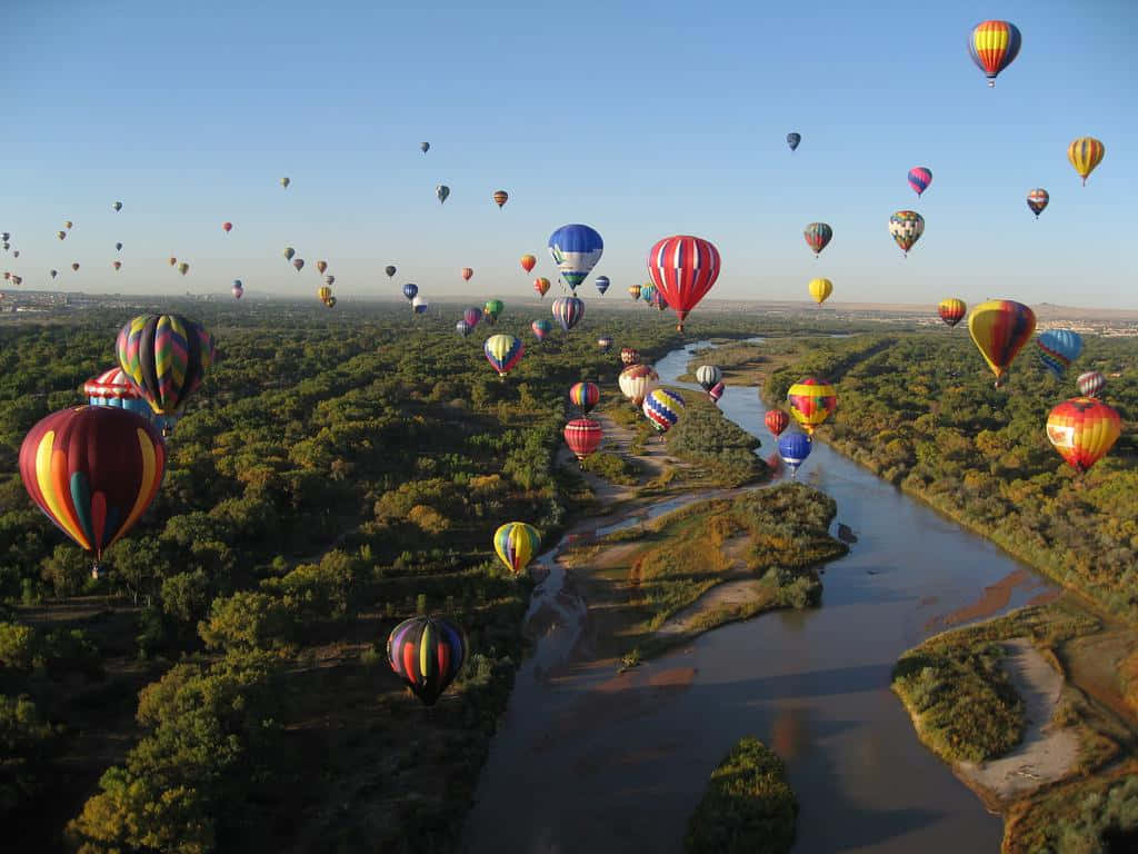 Hot Air Balloons Flying Over A River
