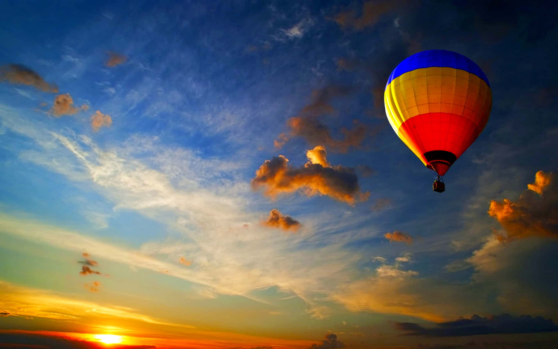 A Hot Air Balloon Flying In The Sky At Sunset