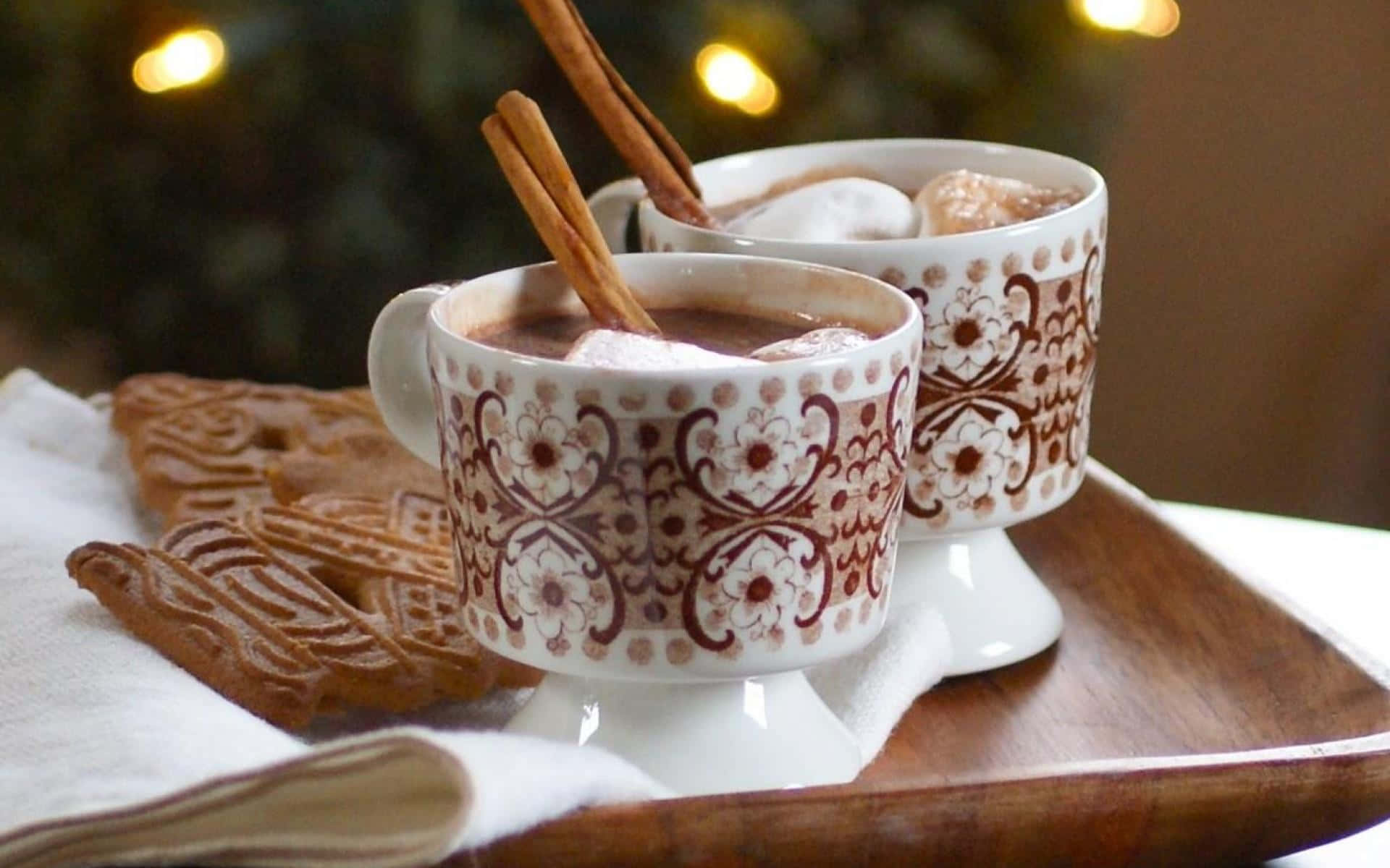 A steaming cup of hot chocolate with marshmallows surrounded by festive decorations Wallpaper